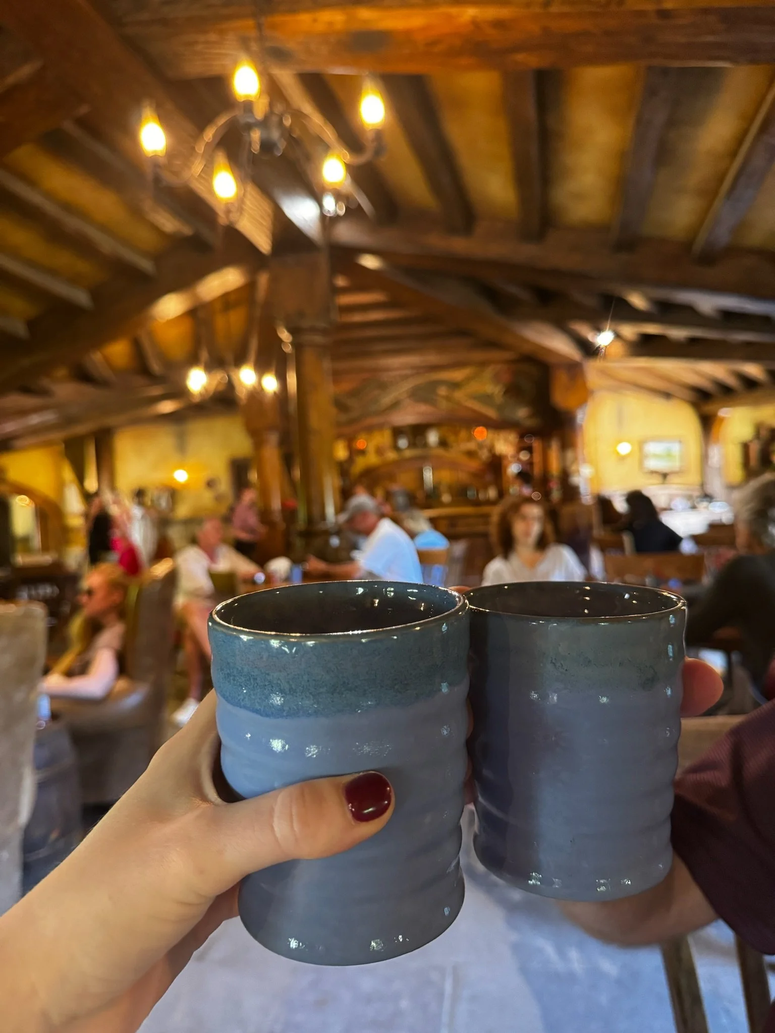 Two mugs of beer at Green Dragon Inn Hobbiton with cozy pub interior in background