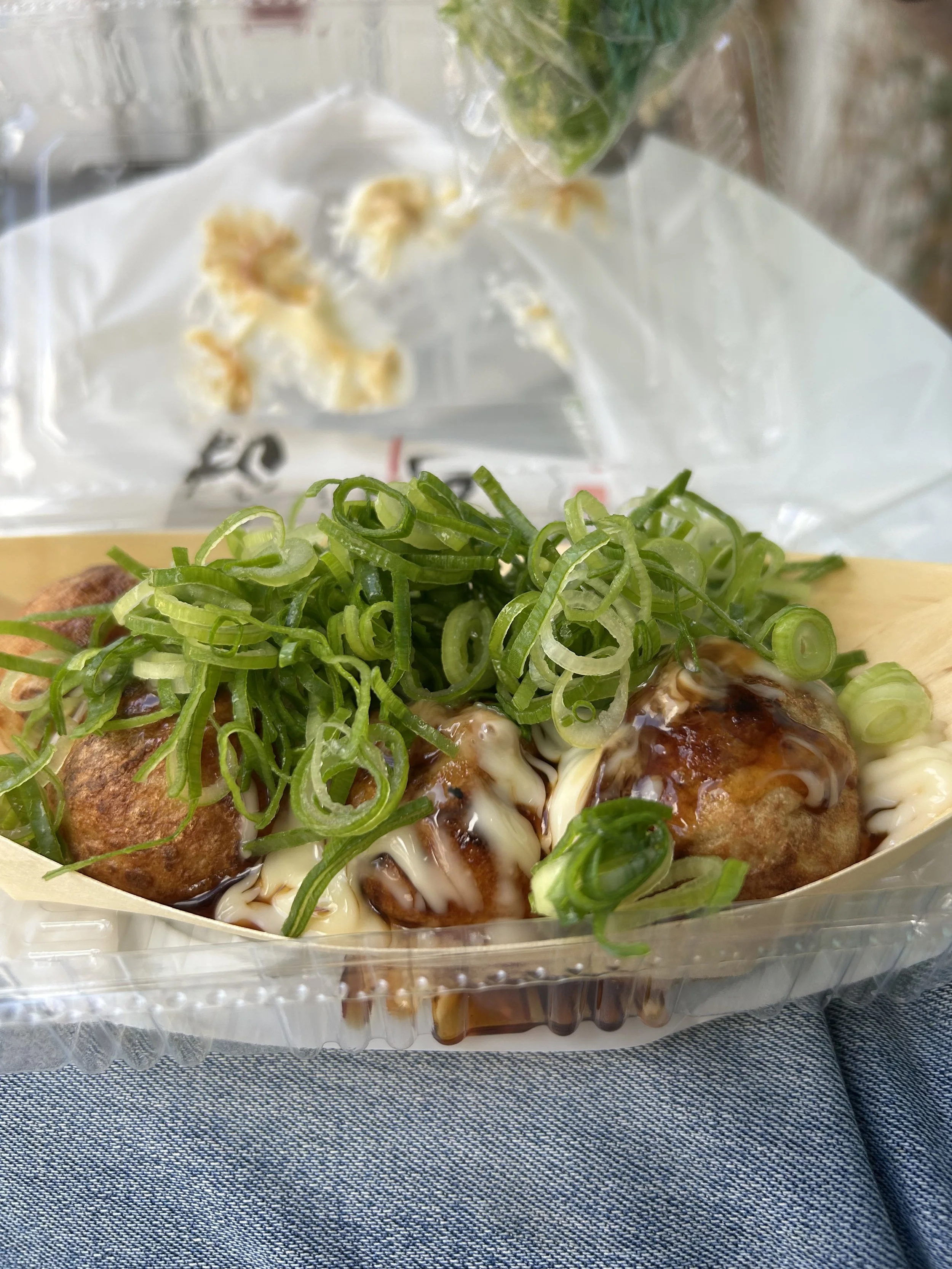 Takoyaki street food in Osaka topped with green onions, sauce, and Japanese mayonnaise