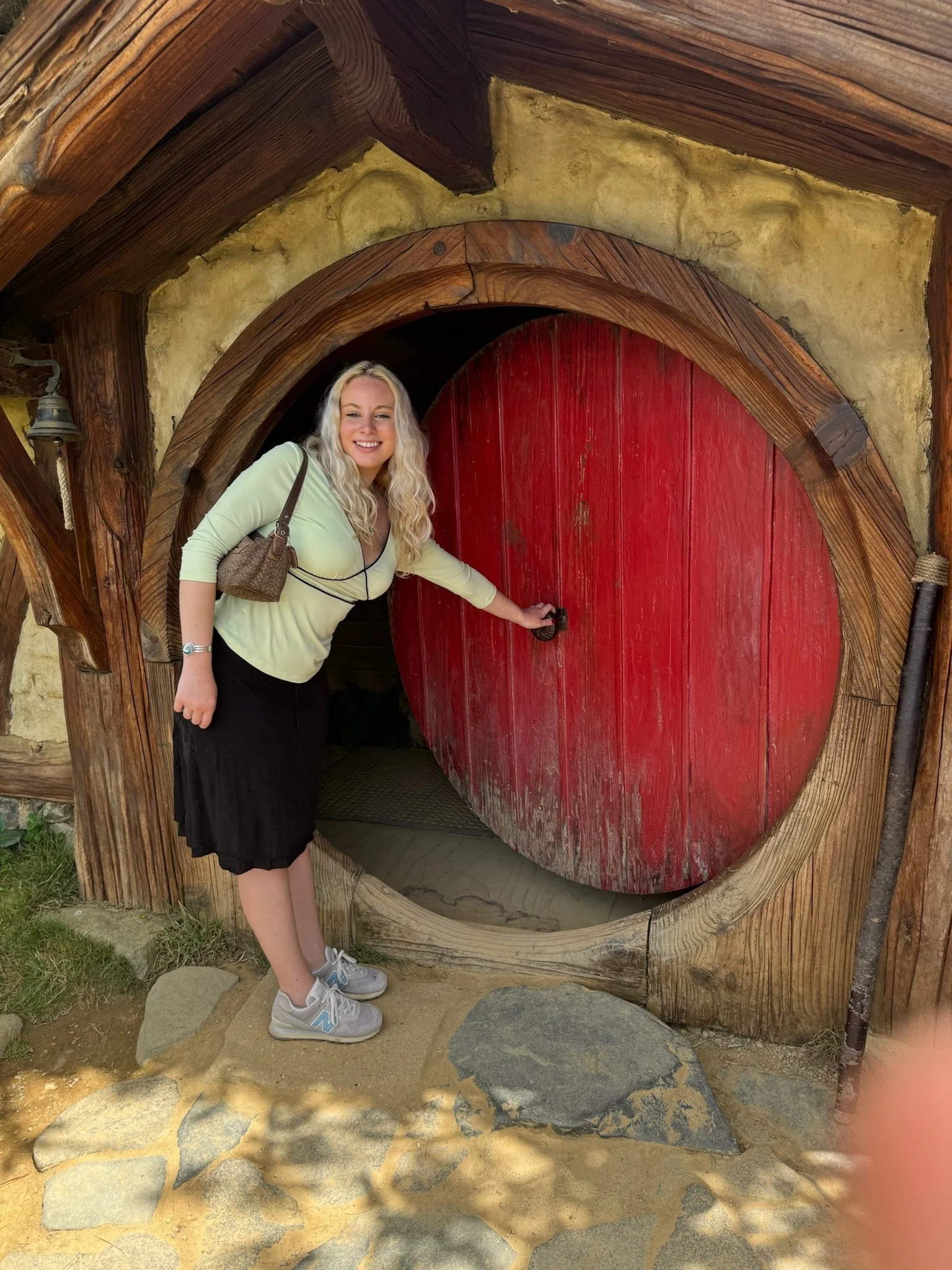 Visitor overlooking Hobbiton Movie Set gardens and hobbit holes