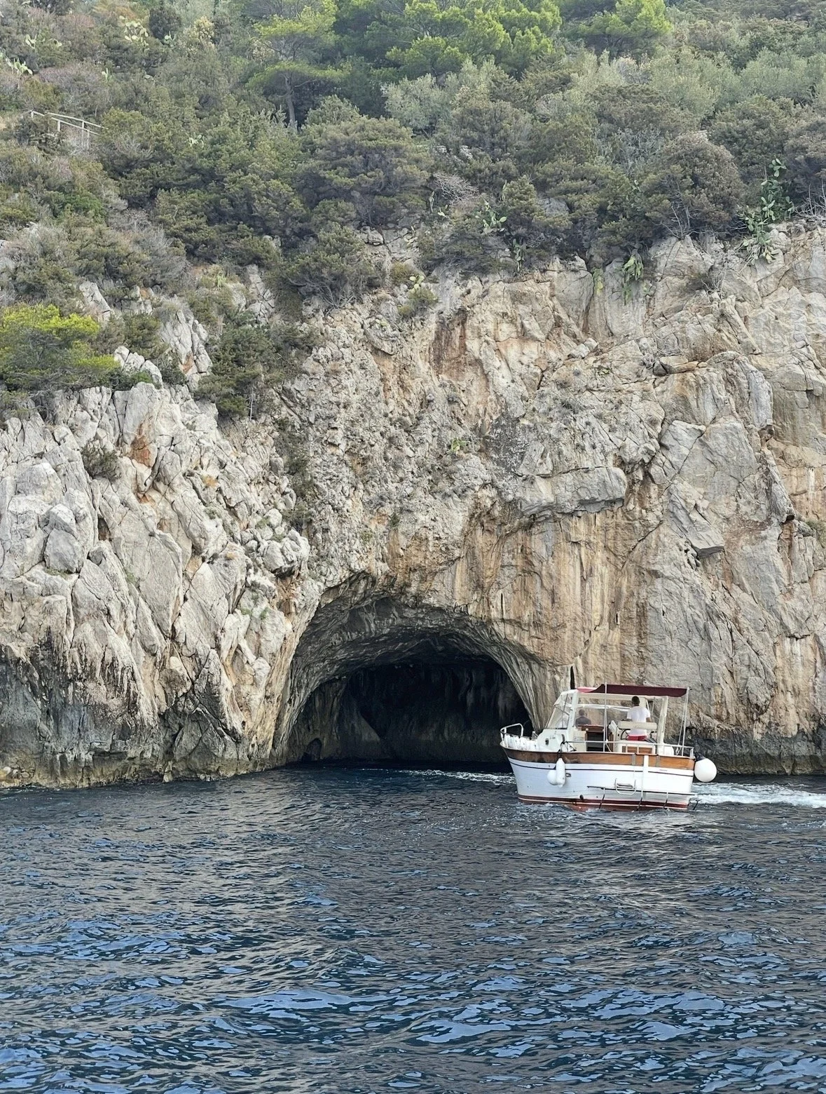 Boat waiting outside the Blue Grotto sea cave on Capri, Italy