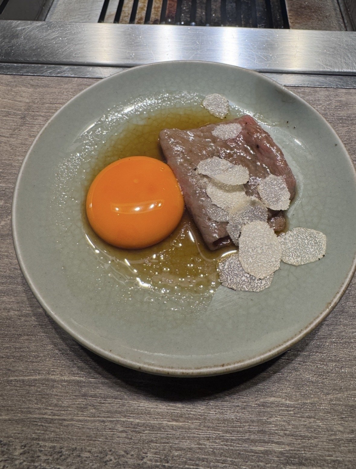 A5 wagyu topped with fresh truffle and egg yolk at Ushigoro S. Ginza in Tokyo.