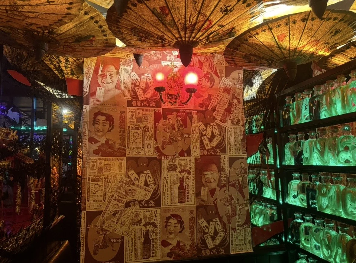Neon-lit interior of Salmon Guru in Madrid with illuminated bottles and colorful parasols