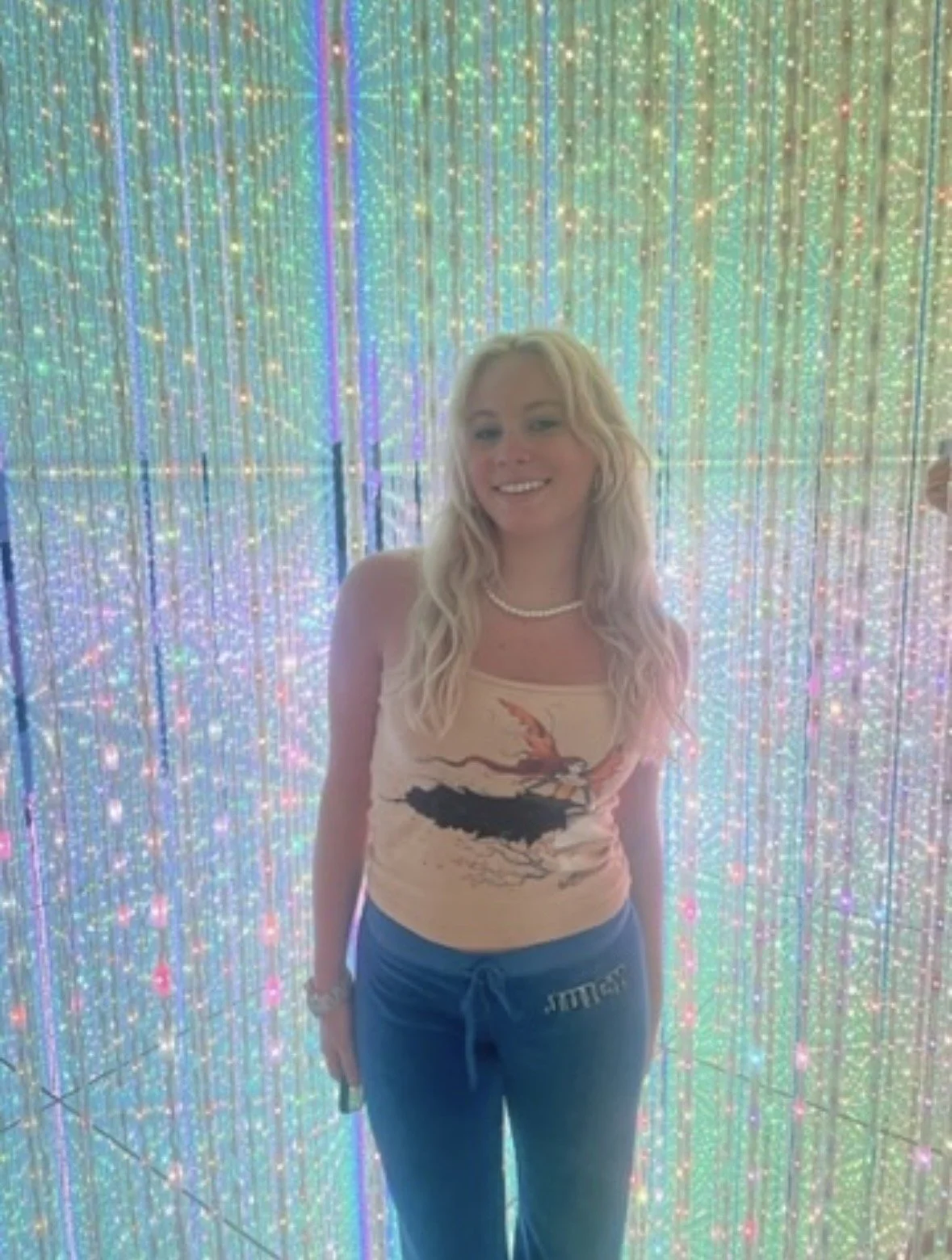 Visitor surrounded by shimmering light installation at teamLab Planets Tokyo.