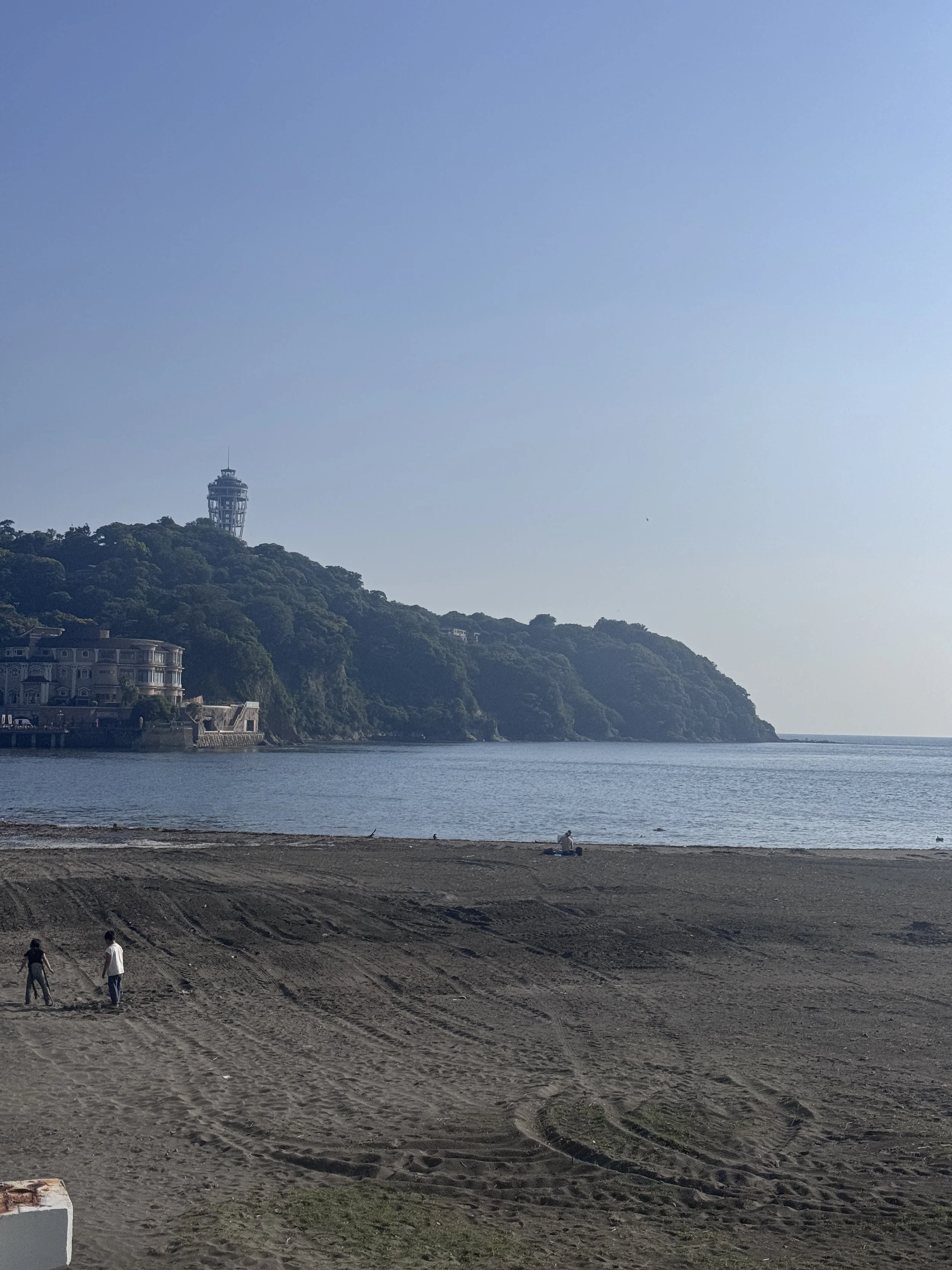 Enoshima beach with Sea Candle tower visible on the hillside