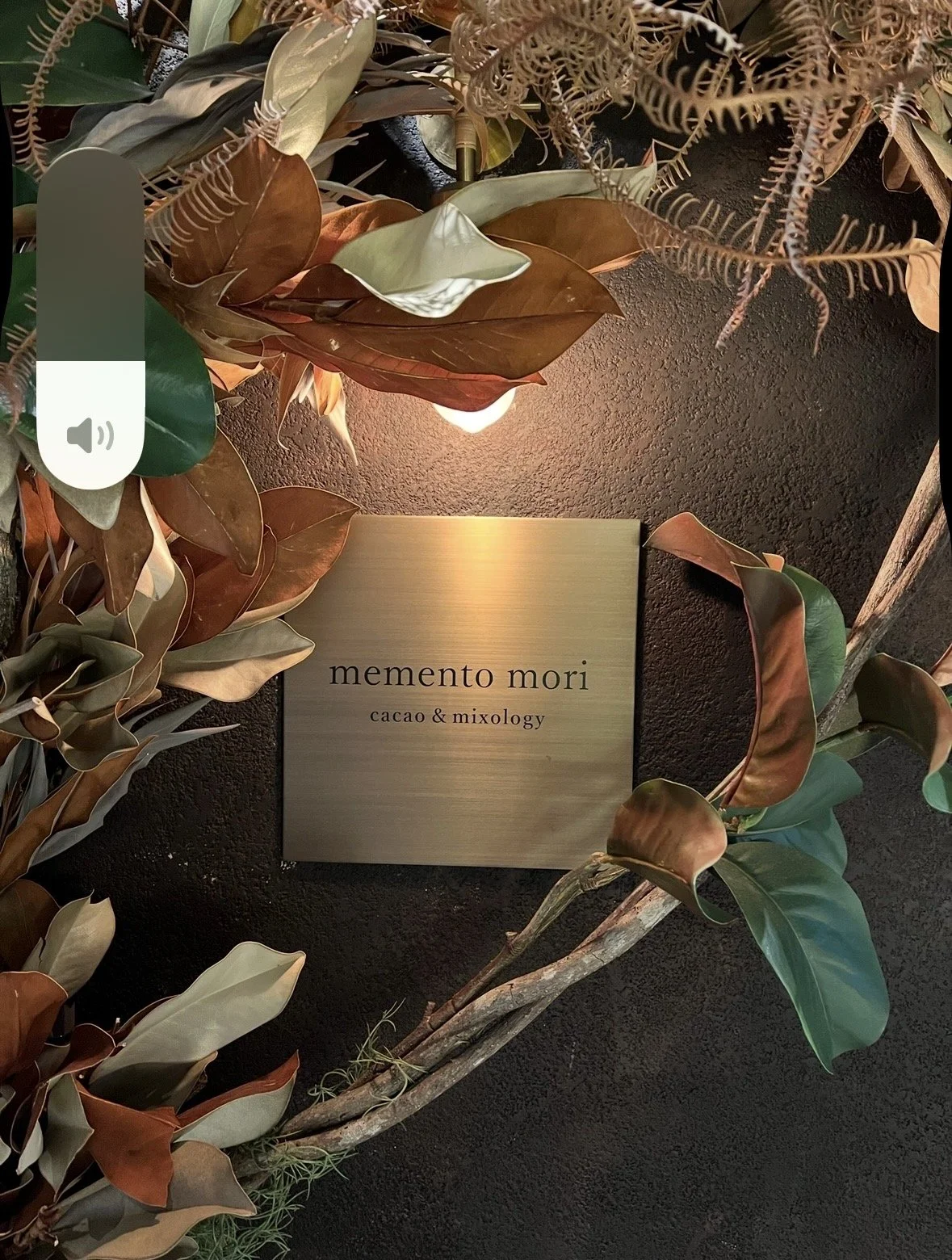 Memento Mori entrance plaque surrounded by greenery at one of Tokyo's hidden cocktail bars