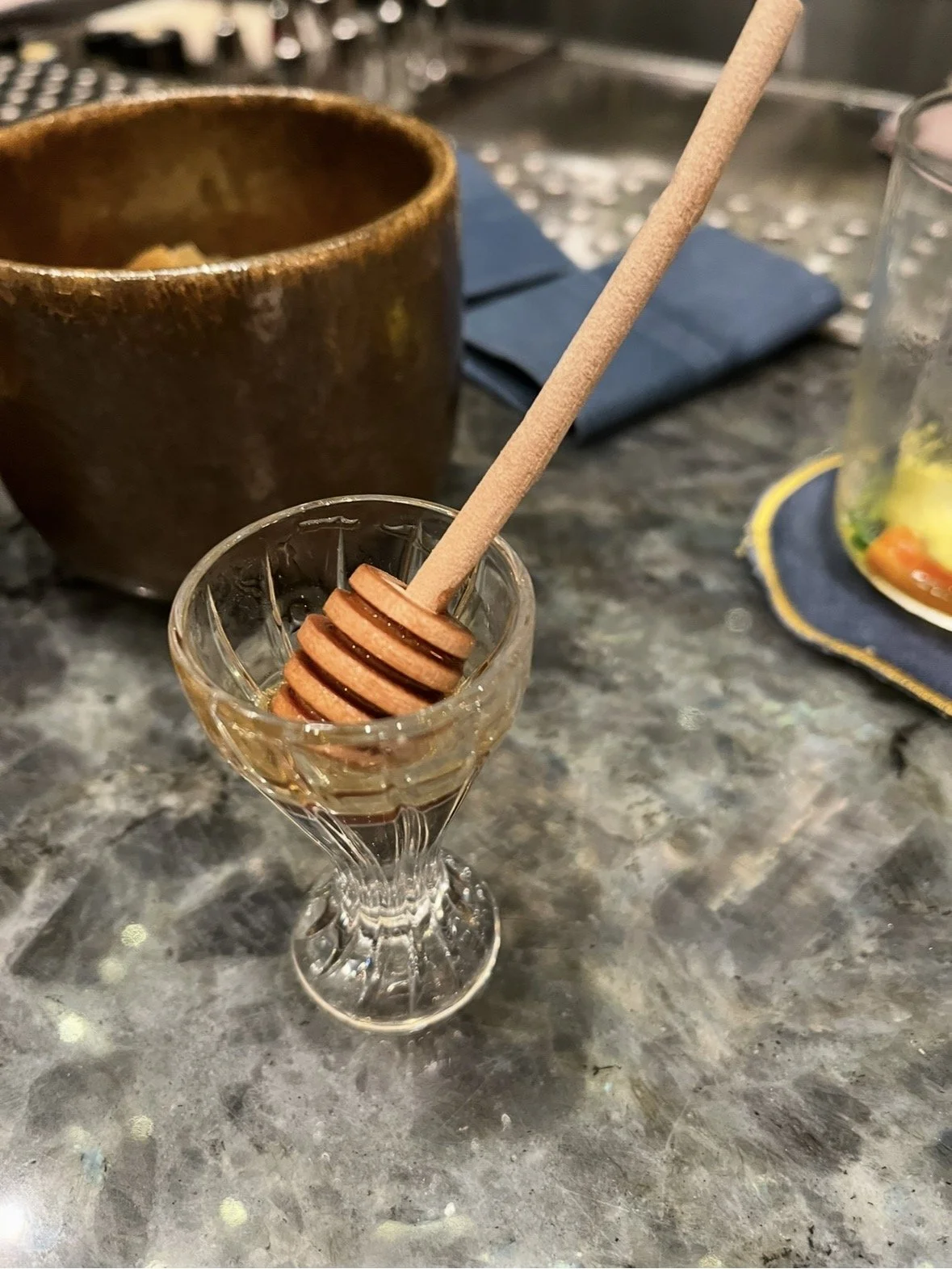 Trigona honey served with a wooden honey dipper at Bar Trigona