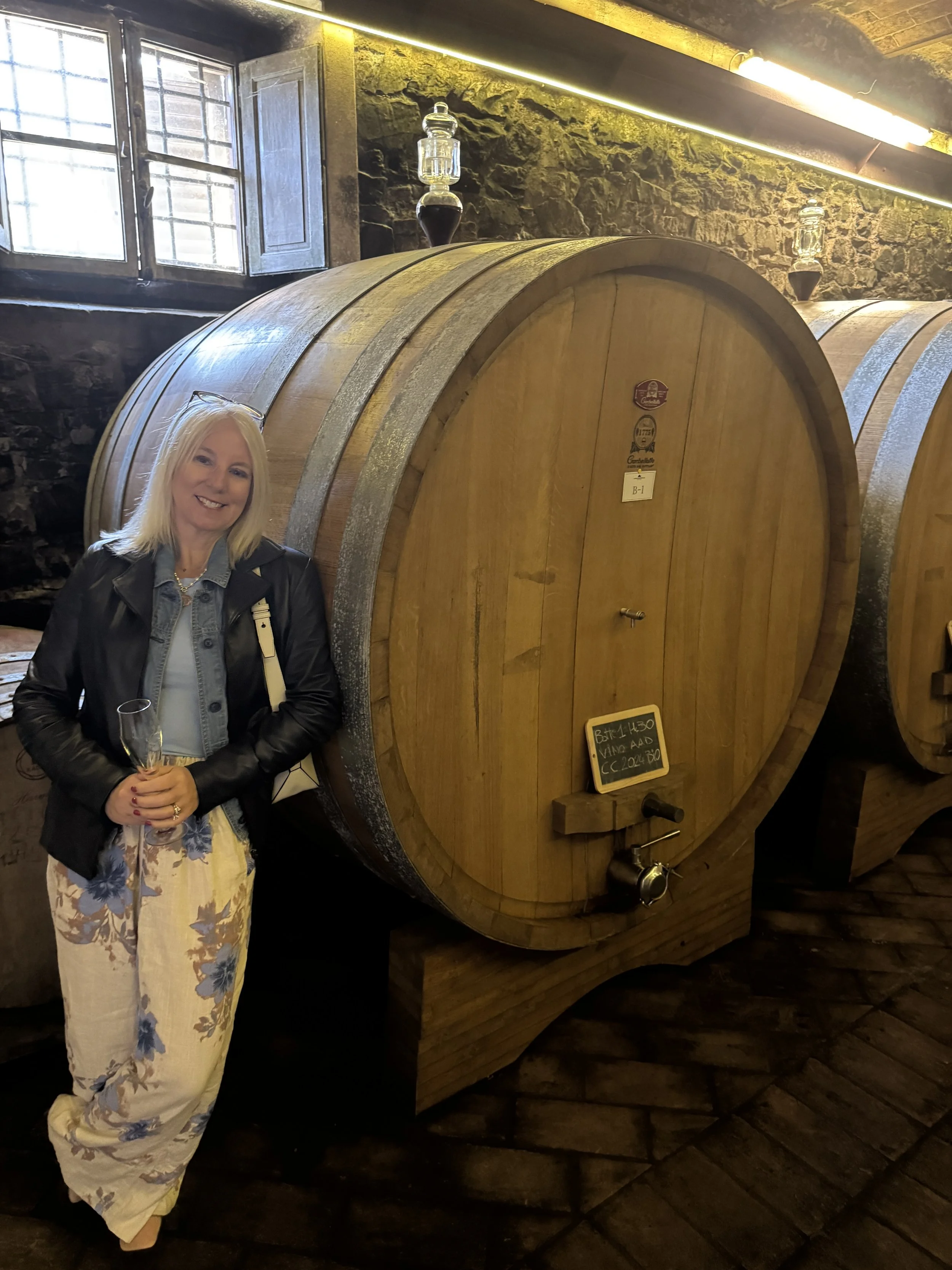 Traditional wine cellar and large wooden barrel at Castello Monterinaldi in Chianti Classico