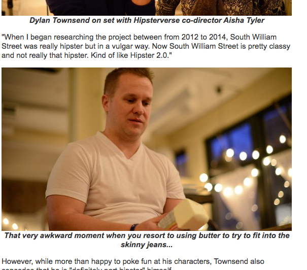 Michael Coleman, star of Hipsterverse sitting indoors, holding a block of butter, with a neutral expression. The background features large windows with string lights at night.