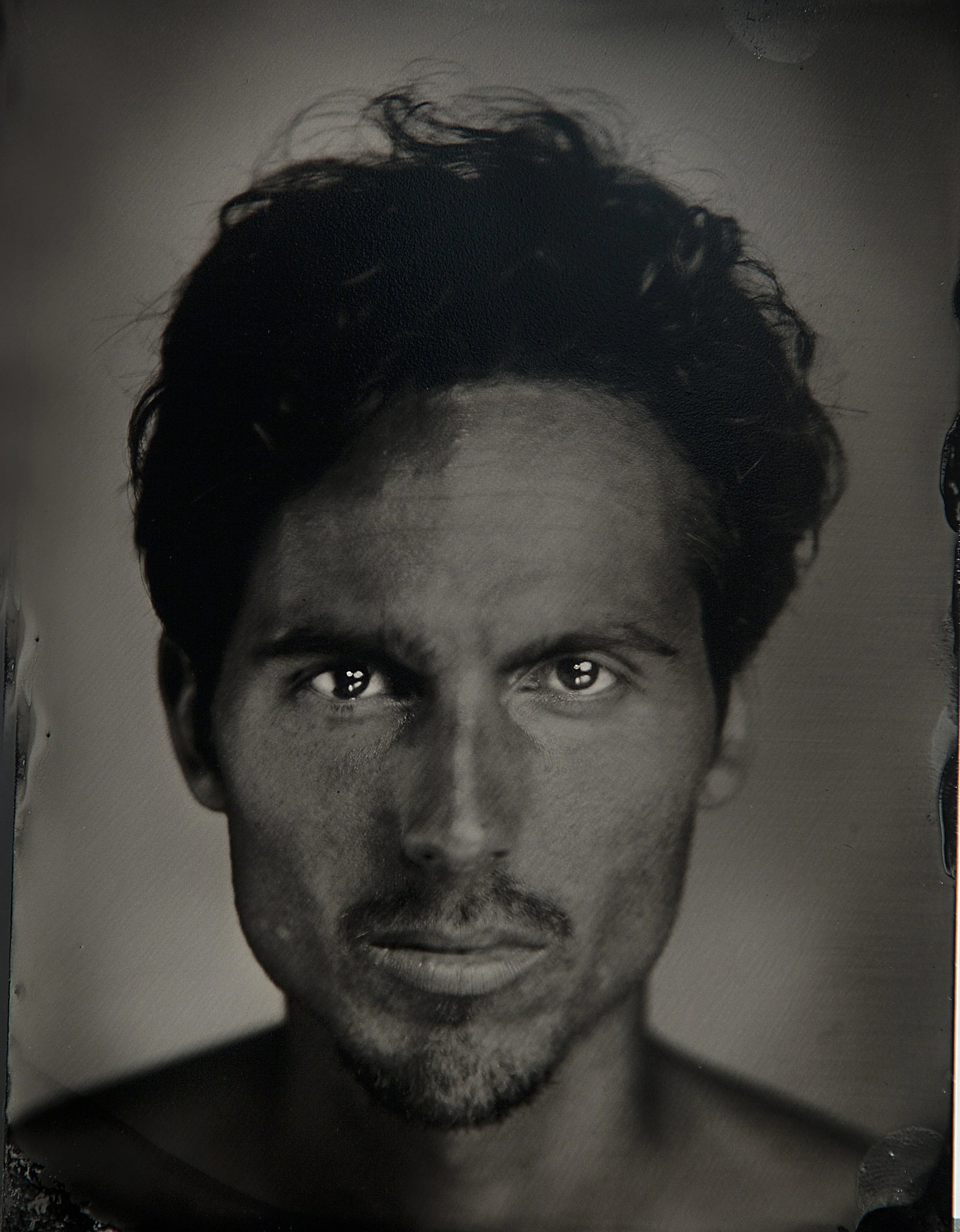 Dylan Townsend Black and white close-up photo of a Man's face with styled hair and intense gaze.