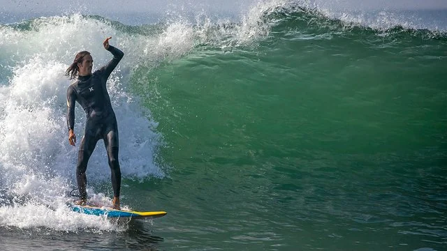 Dylan Townsend in a wetsuit surfing on a wave in the ocean.