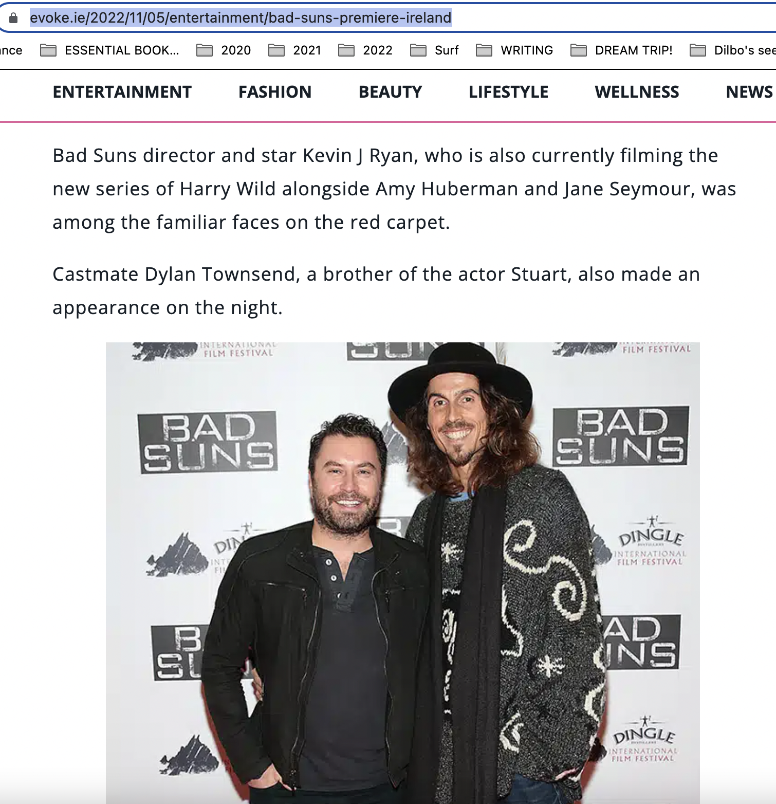  standing together at a red carpet event for the film 'Bad Suns'. The man on the left has short hair, a beard, and is wearing a black jacket. The man on the right has long, curly hair, a mustache, a goatee, and is wearing a large black hat and a blac