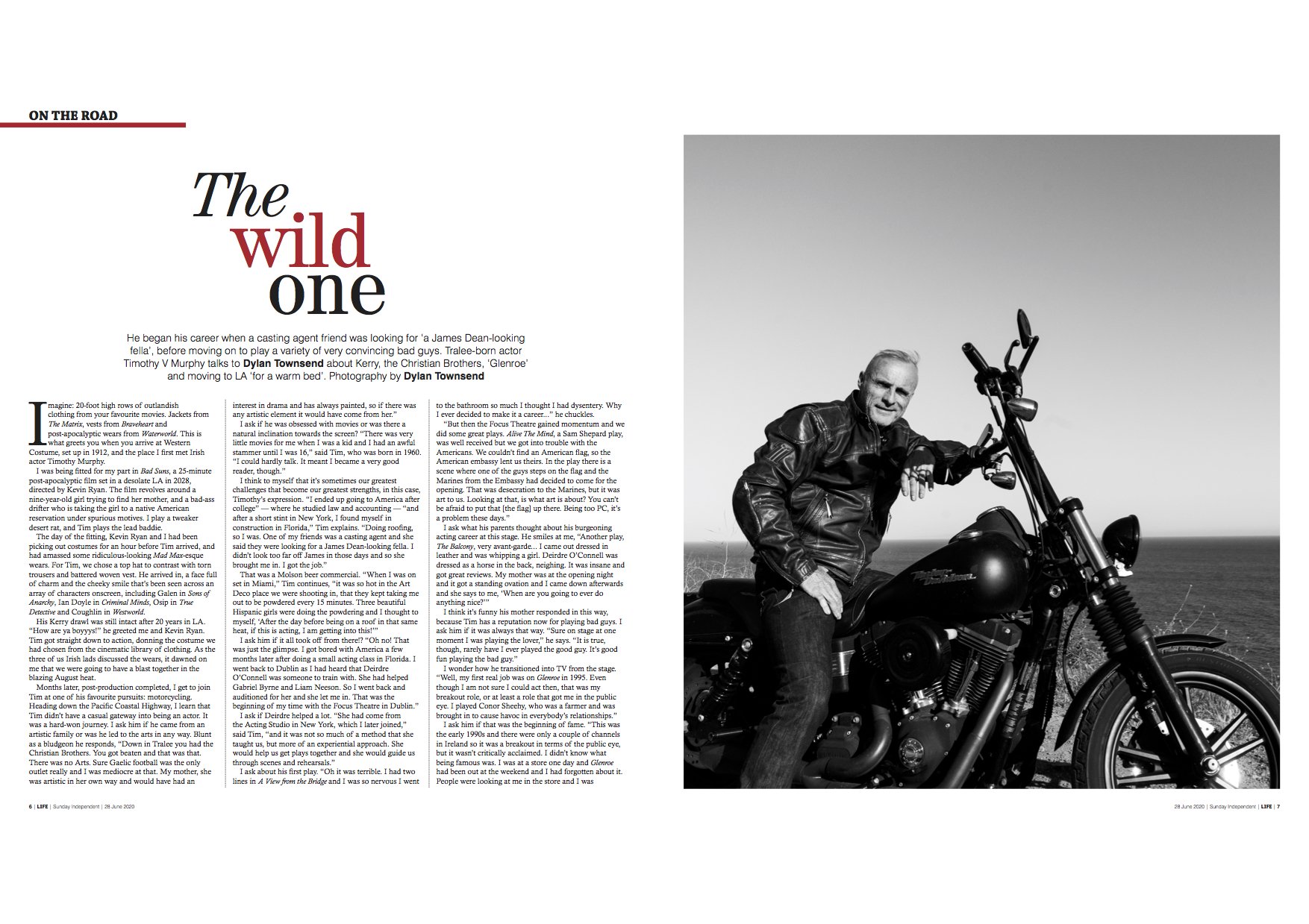 Timothy V. Murphy in a Black and white photo of a smiling man with gray hair and beard, sitting on a motorcycle on a beach, wearing a leather jacket. Dylan Townsend mentioned as photographer.