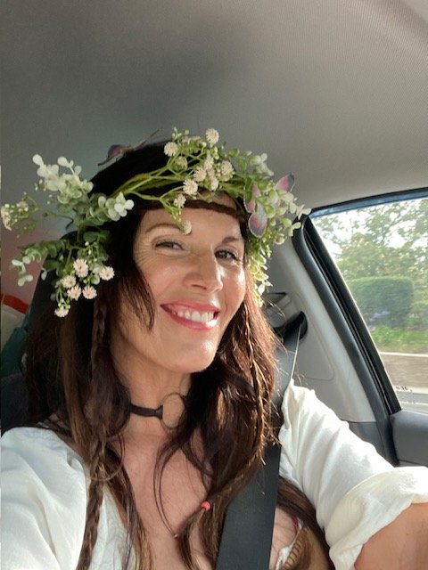 Julie Ann Beijer wearing a flower crown, smiling in a car.