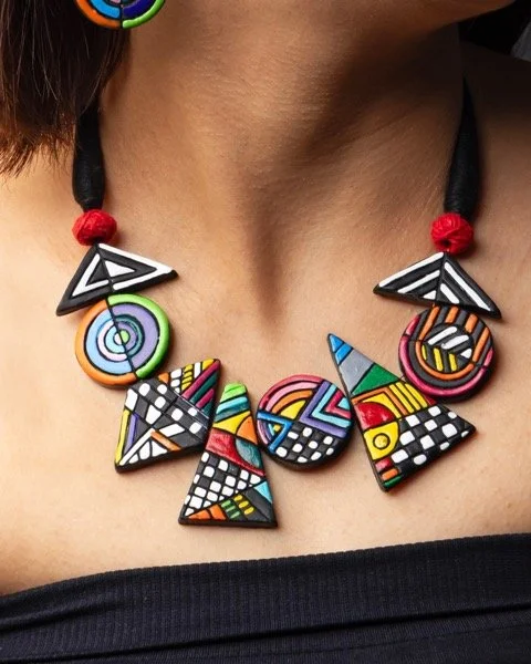 Colorful geometric beaded necklace with abstract patterns worn around the neck of a person.