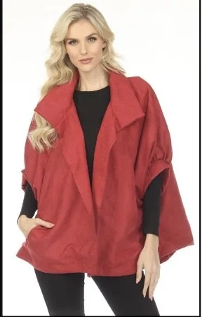 Woman with long blonde hair wearing a red oversized jacket over a black top and black pants.