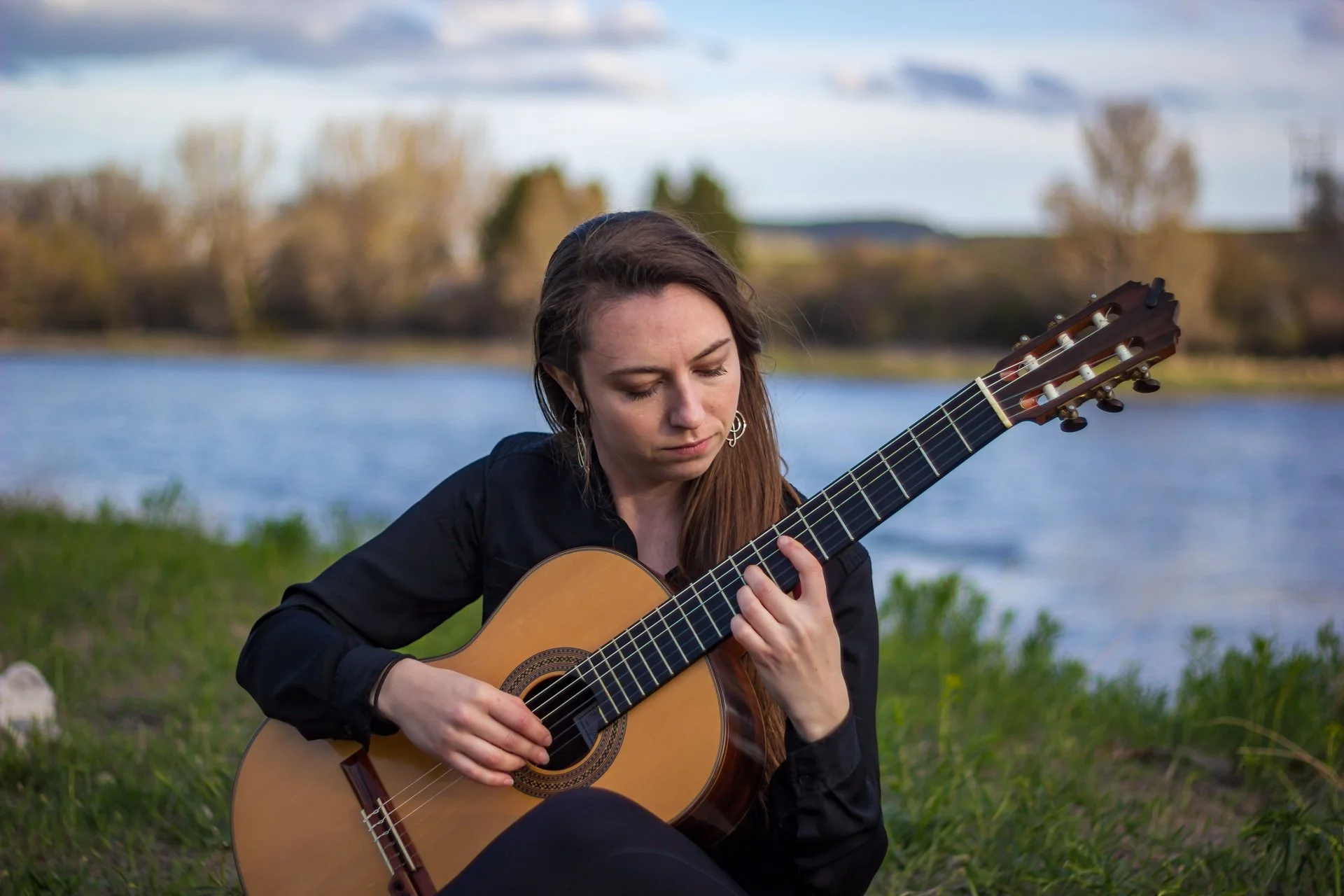 Devin Matthews playing guitar alongside the Yellowstone River.