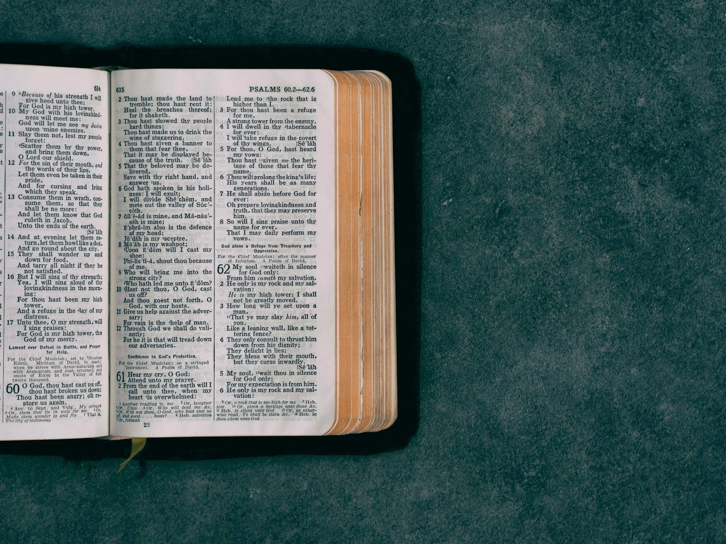 Open Bible to Psalms 60-62, resting on a teal surface.