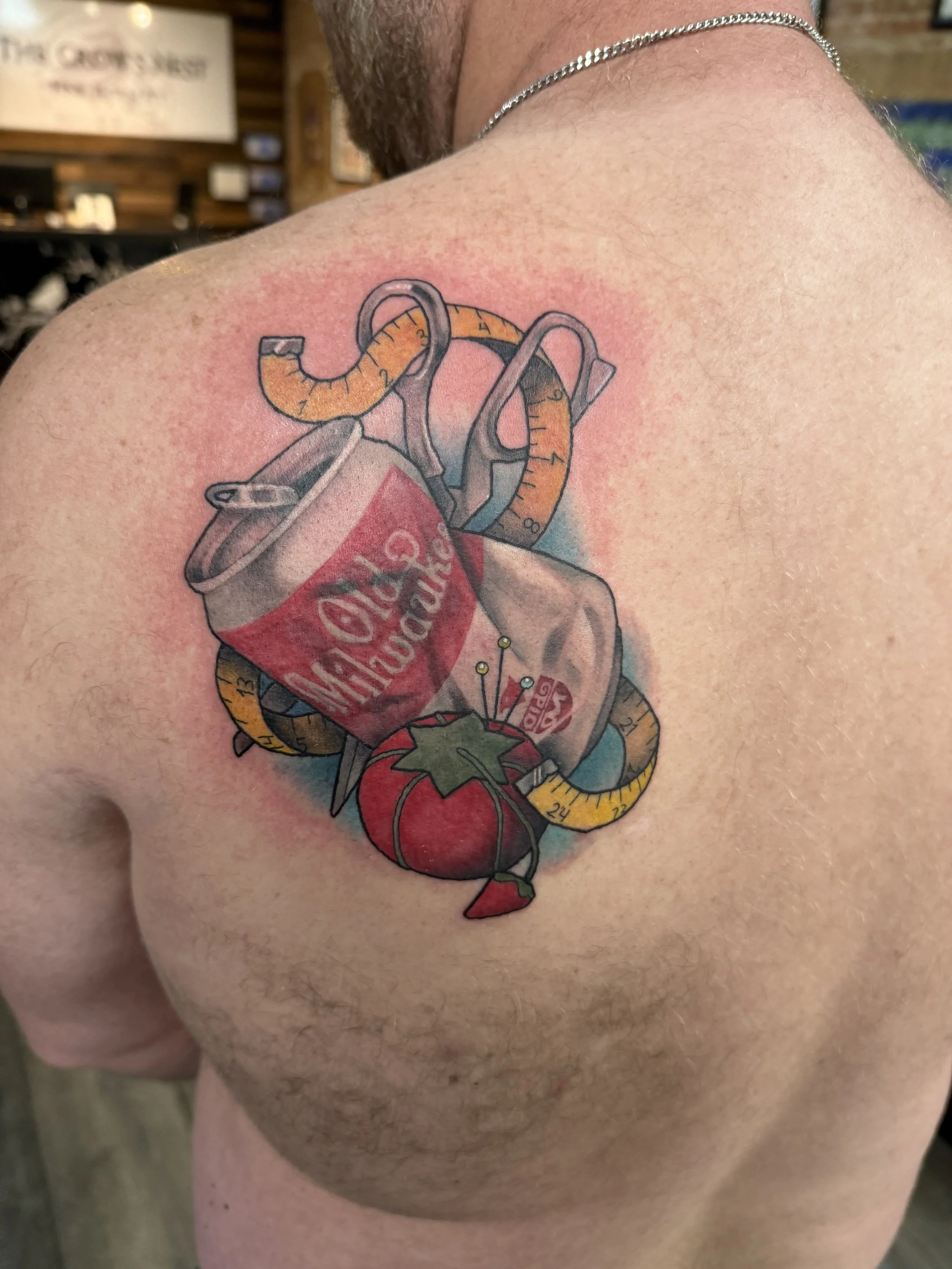 Colorful tattoo of a Coca-Cola can with a tape measure wrapped around it and a chili pepper at the bottom.