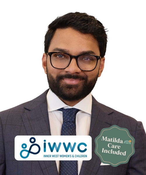 A man wearing glasses, a suit, and a tie, smiling in front of a black background with the INWWC logo and a badge that says "Matilda Care Included."