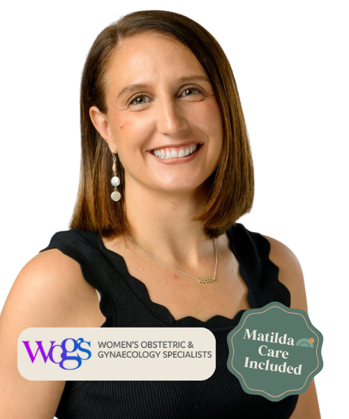 A smiling woman with shoulder-length brown hair, wearing a black sleeveless top, earrings, and a delicate necklace, standing against a background with text and graphics indicating Women's OB-GYN and gynecology services, including Matilda Care.