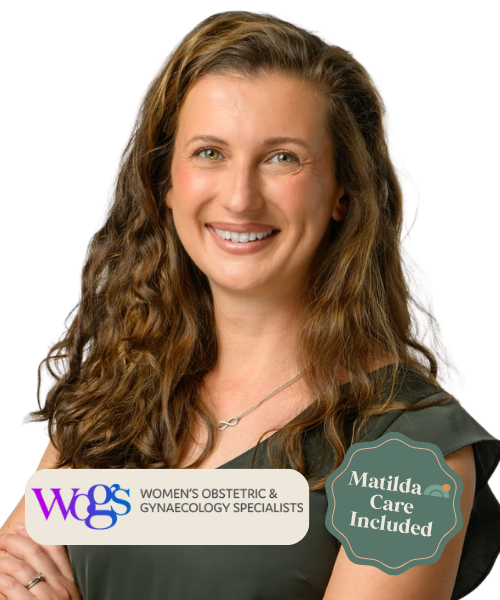 A woman smiling, with long curly hair, holding a sign that says Women's OB-GYN Specialists, with a badge that says Matilda Care Included.