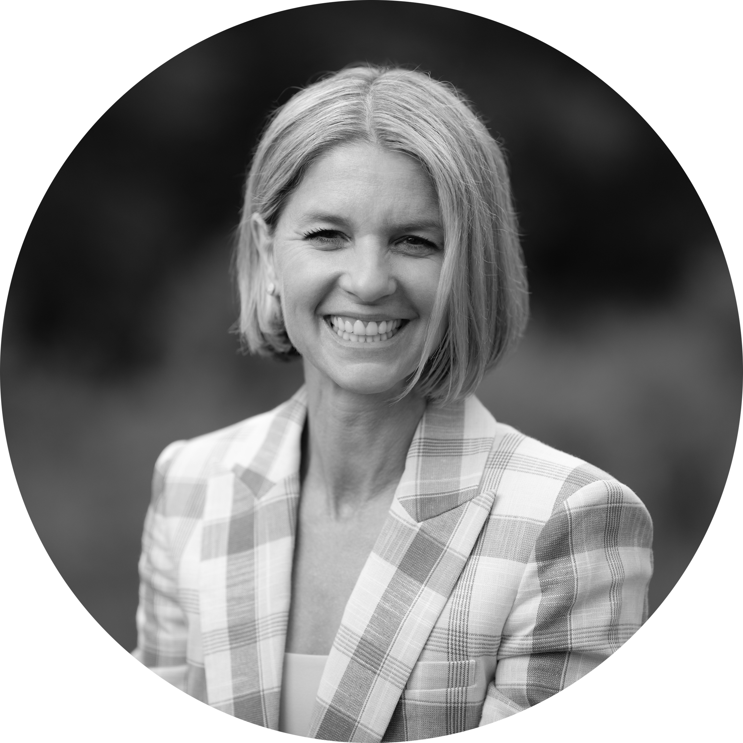 Nicole Mancino, wearing a checkered blazer, in grayscale.