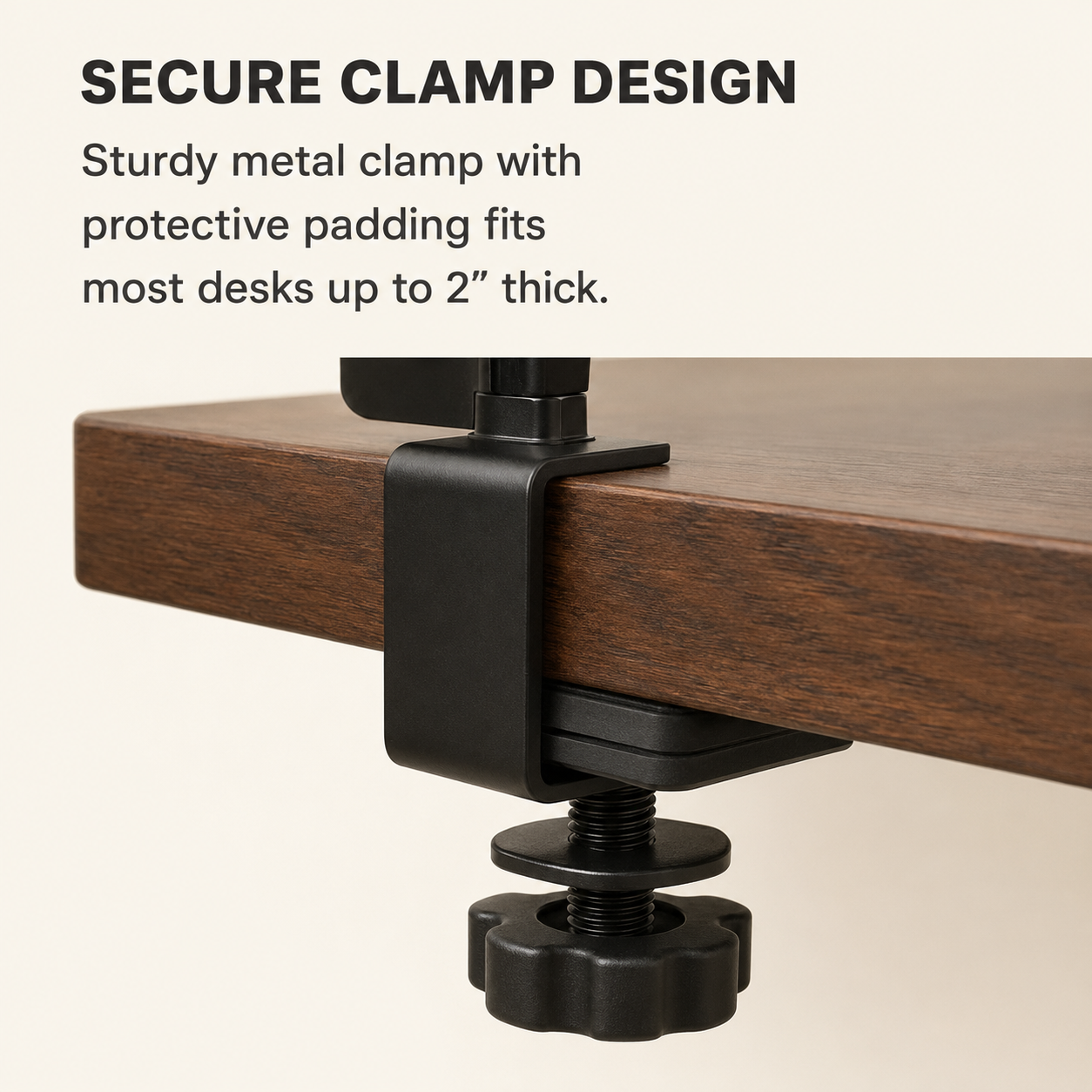 Close-up of a sturdy black metal clamp securing a wooden desk with a screw mechanism visible underneath.