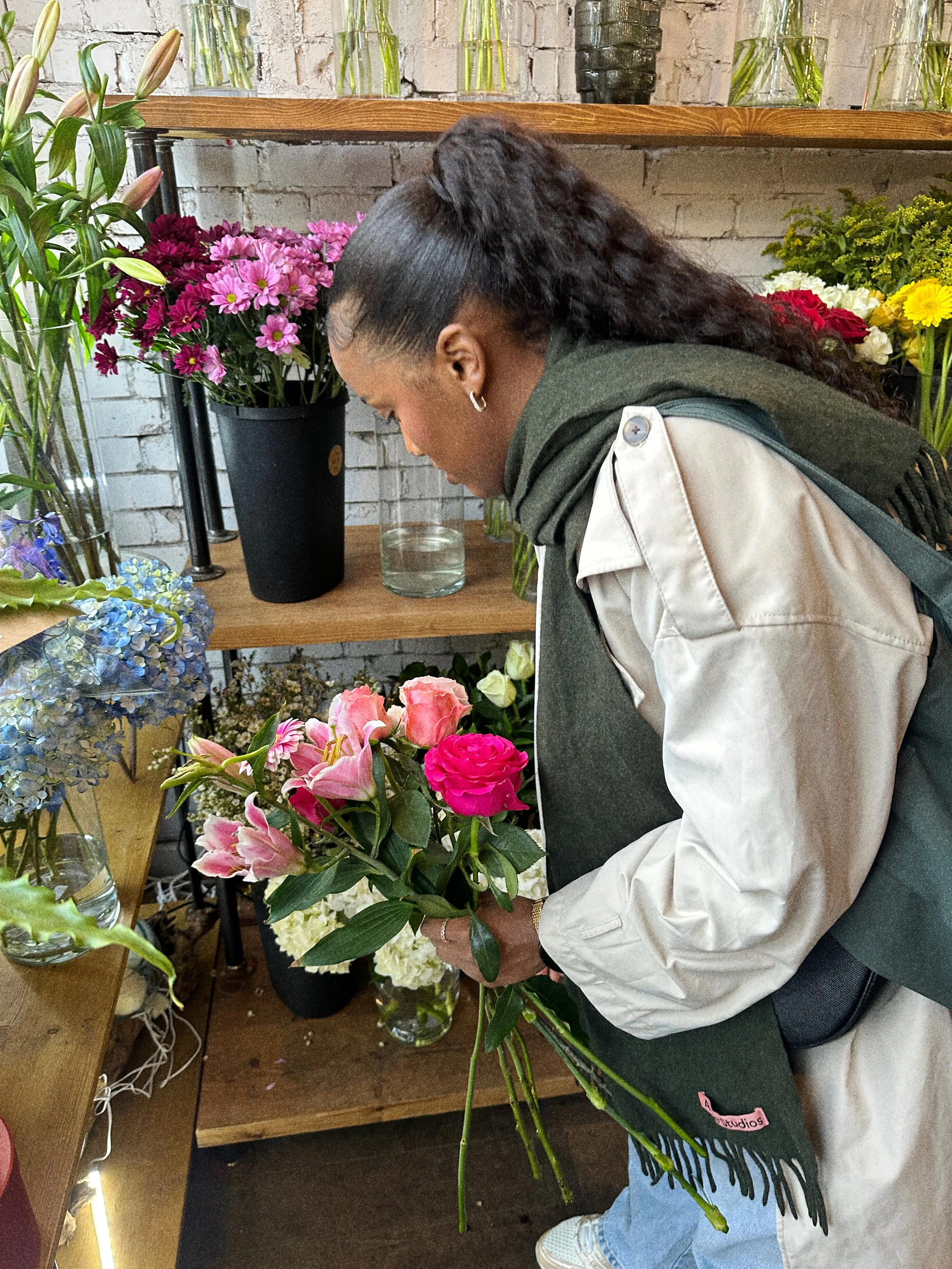 The founder of Petal'd, is arranging flowers from a flower shop. She is designing a floral arrangement