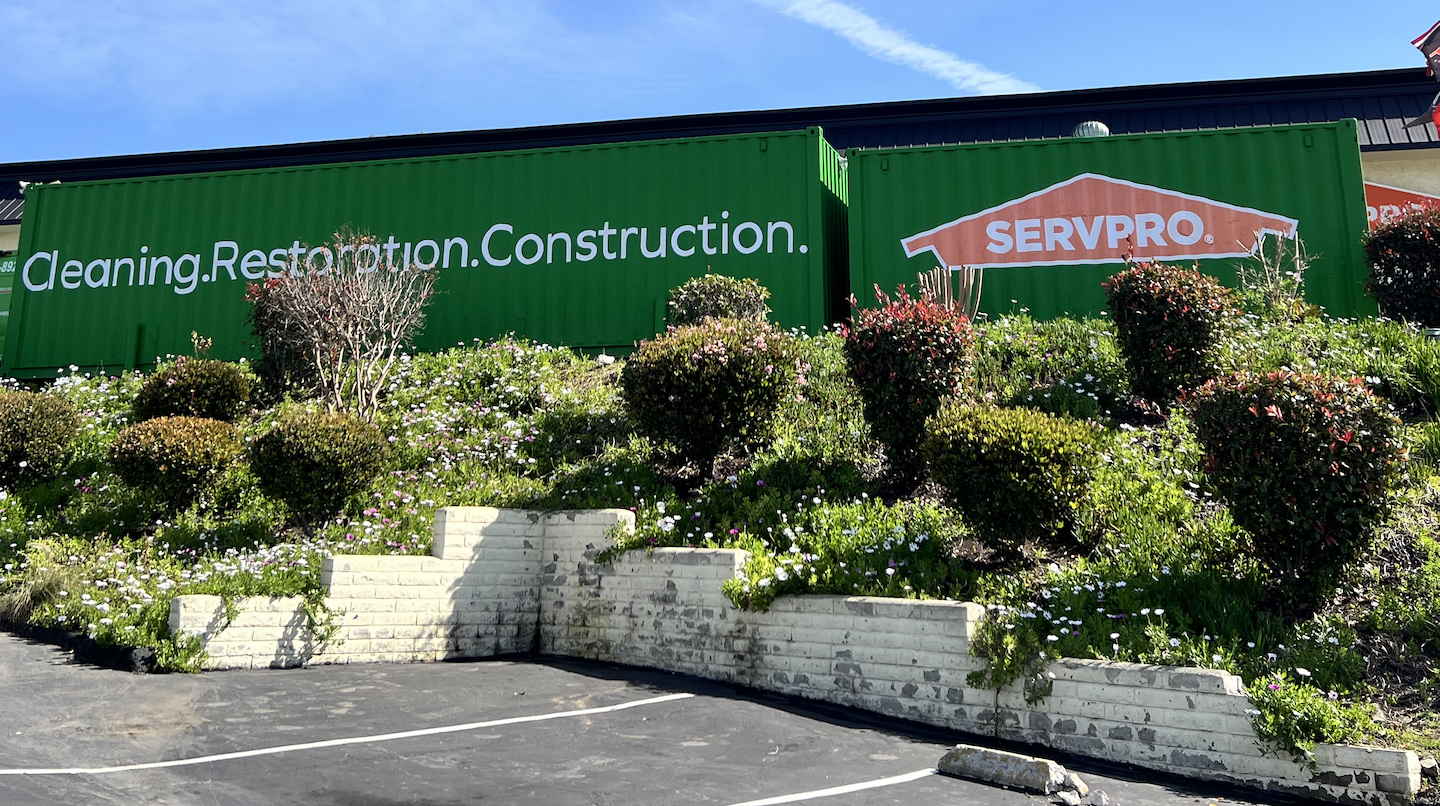 A green construction container with logo graphics done by Reborn Motorwerks to promote it's brand visibility.