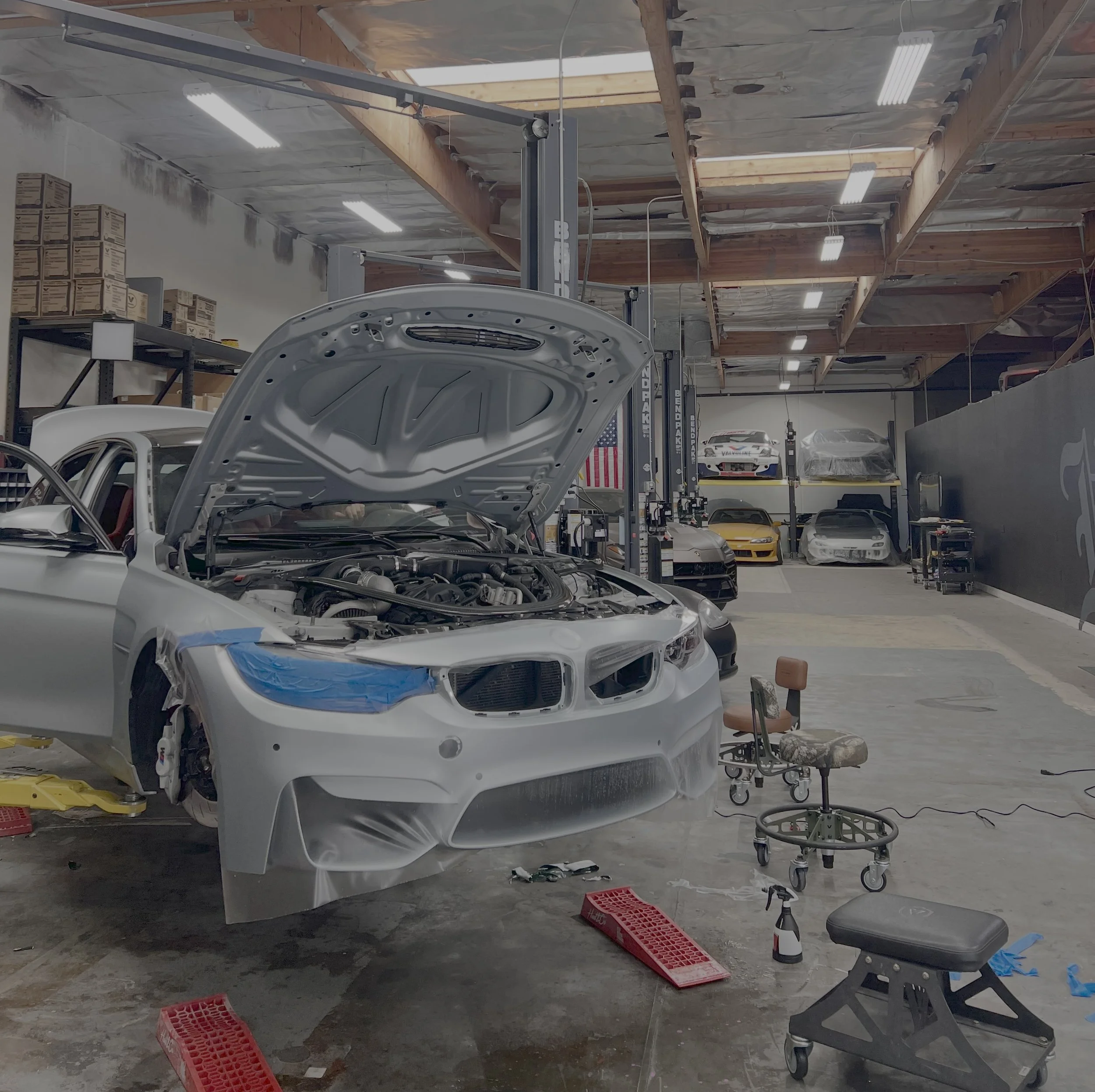 A silver BMW getting paint protection film (PPF) on the front bumper to protect it from scratches and rock chips done by Reborn Motorwerks.