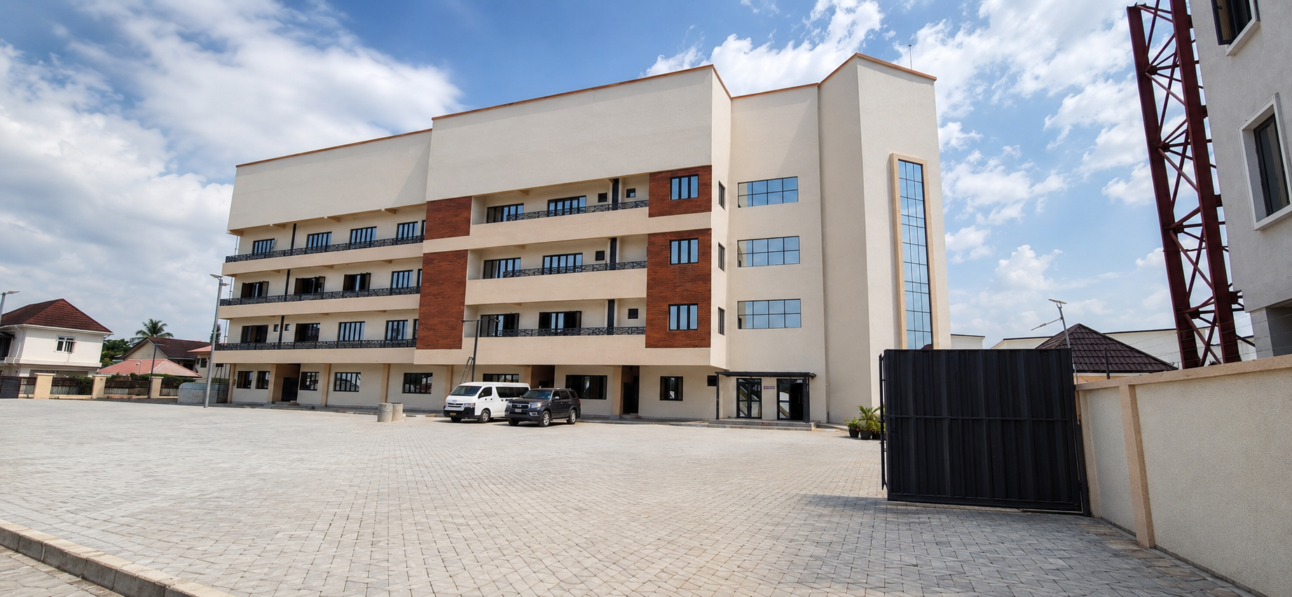 Modern multi-story residential building with balconies, large windows, and a parking lot in front.