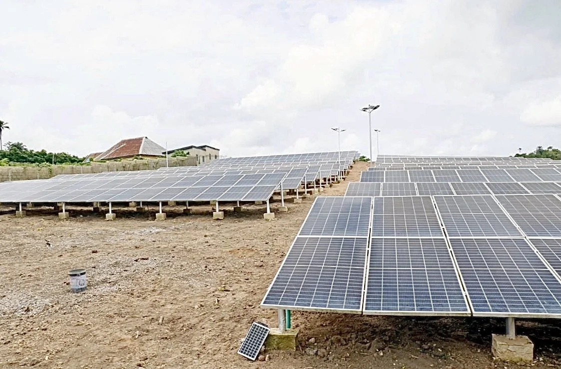 Multiple rows of solar panels installed on the ground under a cloudy sky.