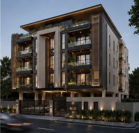 Modern multi-story residential building with balconies, large windows, and a gated entrance, illuminated at dusk, designed by IHOD.