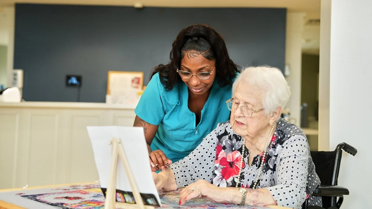 nurse working with resident on jigsaw puzzle
