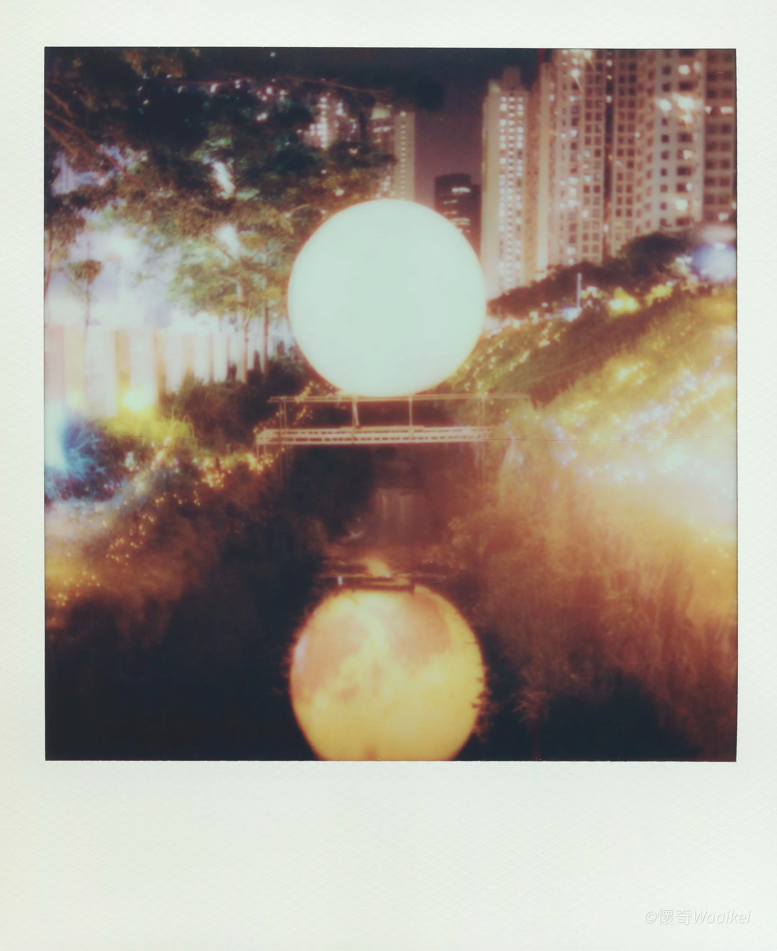 Nighttime cityscape with illuminated buildings and three large glowing orbs in the foreground.