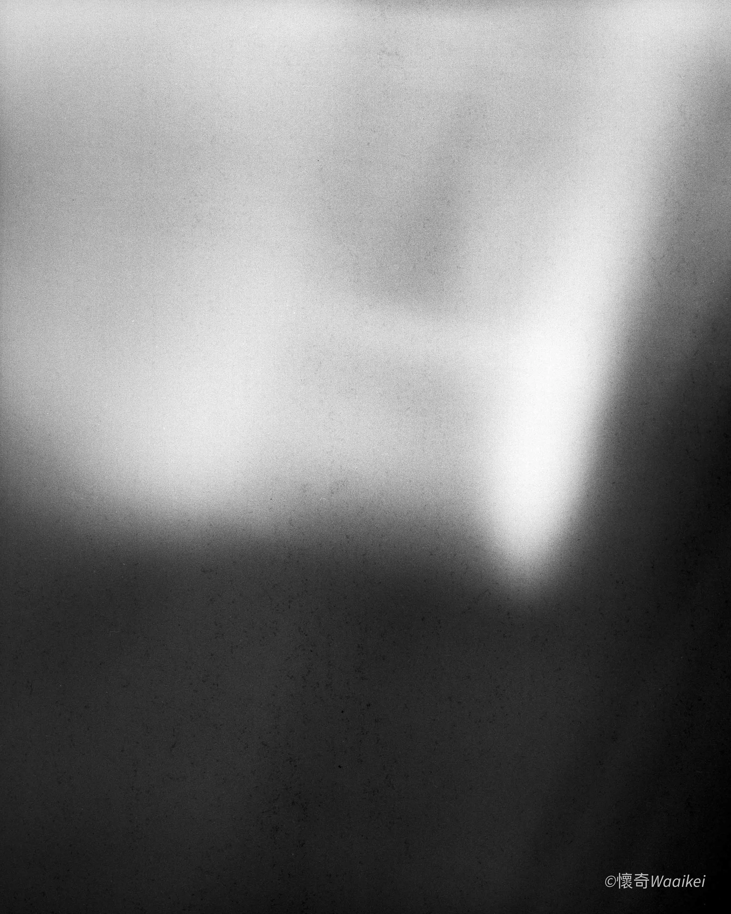 Black and white abstract image with a gradient from light to dark, featuring a central shrouded shape and a textured background.