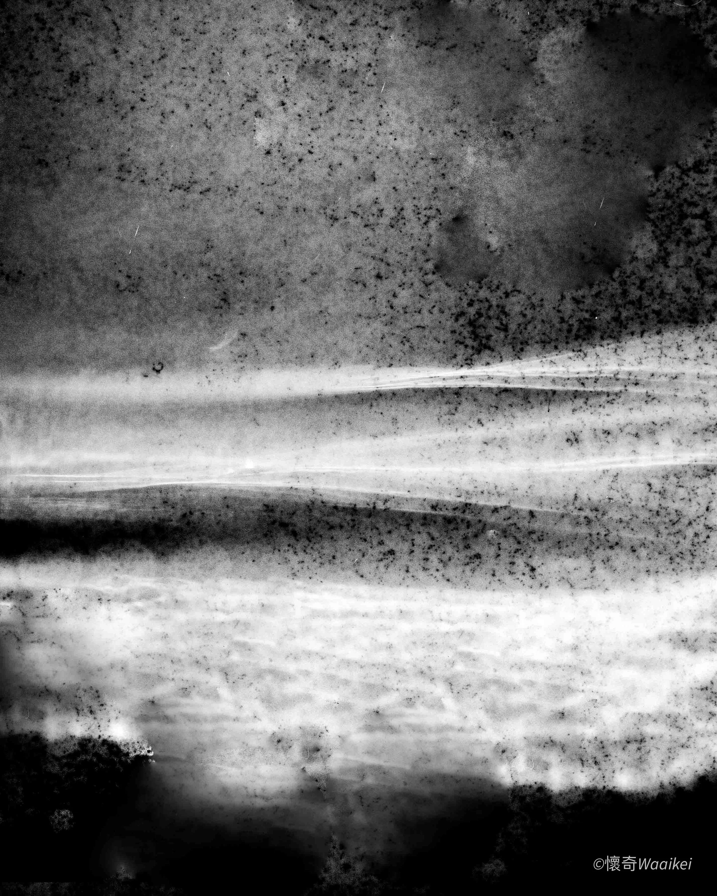 Black and white photograph of a striped pattern on a surface, possibly a close-up of a textured material or a natural pattern with alternating light and dark bands.