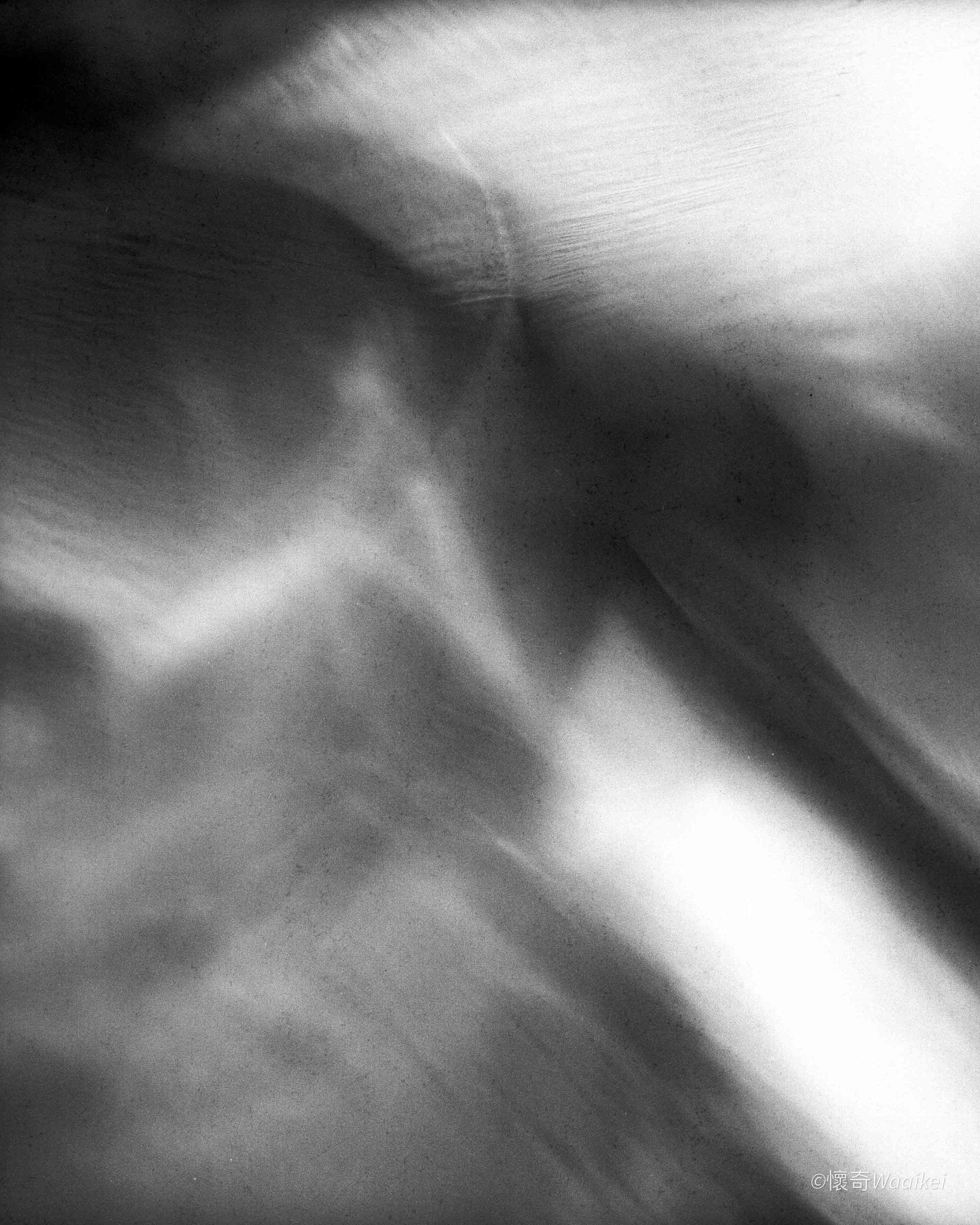 Black and white abstract photo with light streaks and blurred areas.