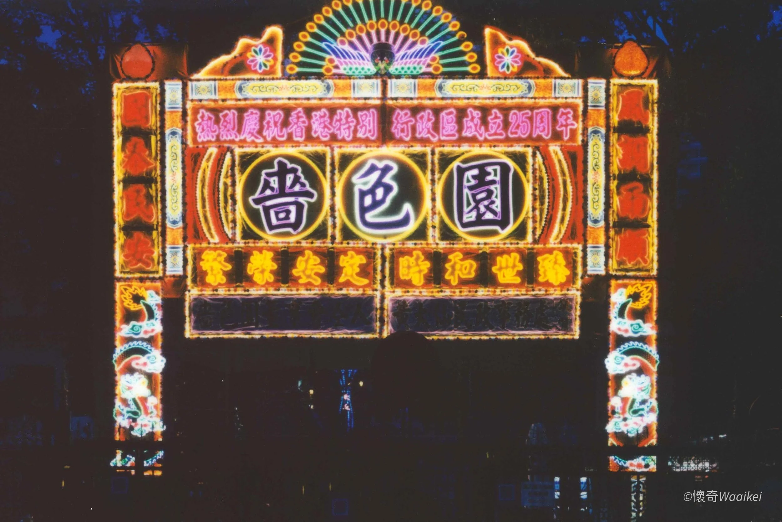 Colorful illuminated sign with Chinese characters celebrating the 25th anniversary of a location, with decorative lights and traditional patterns.