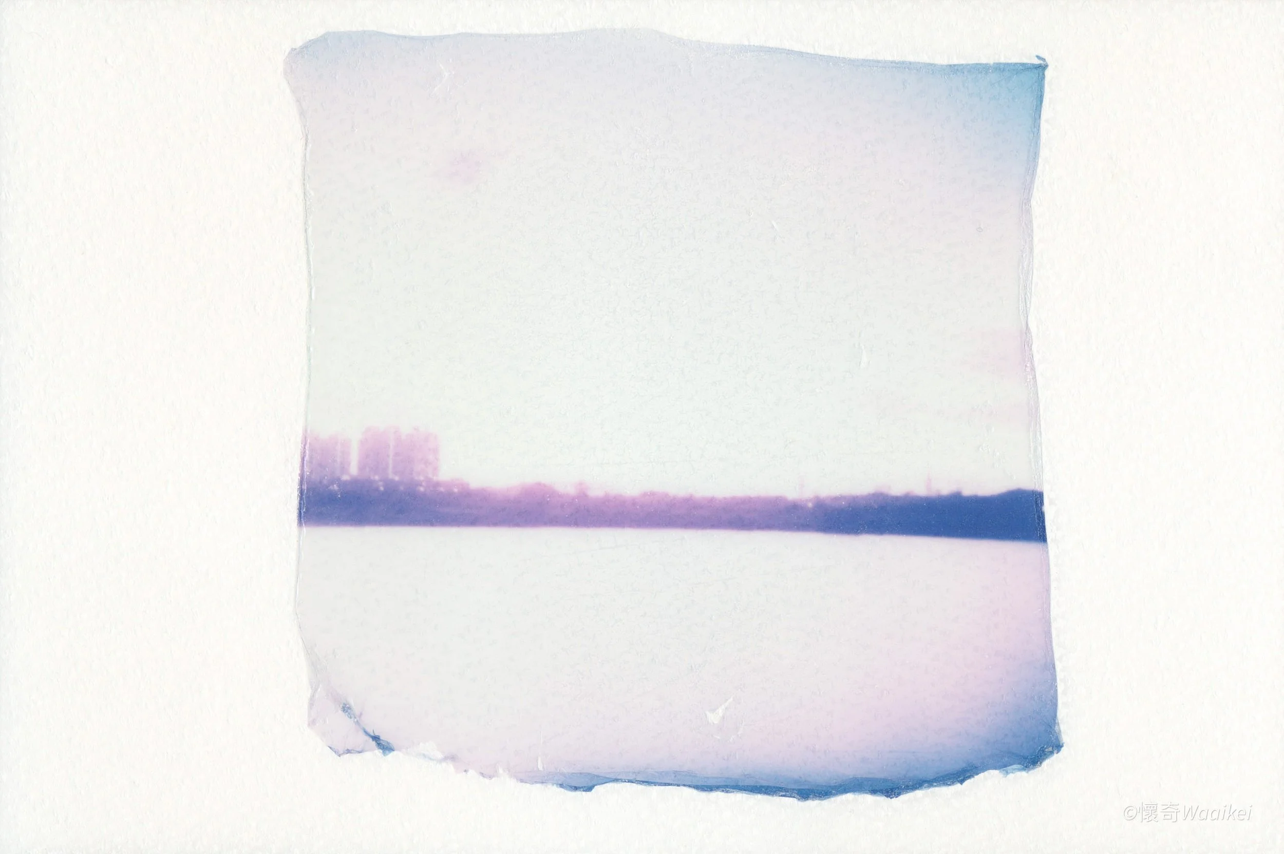 A piece of torn paper with a watercolor-like gradient of purple and blue hues, placed on a white background.