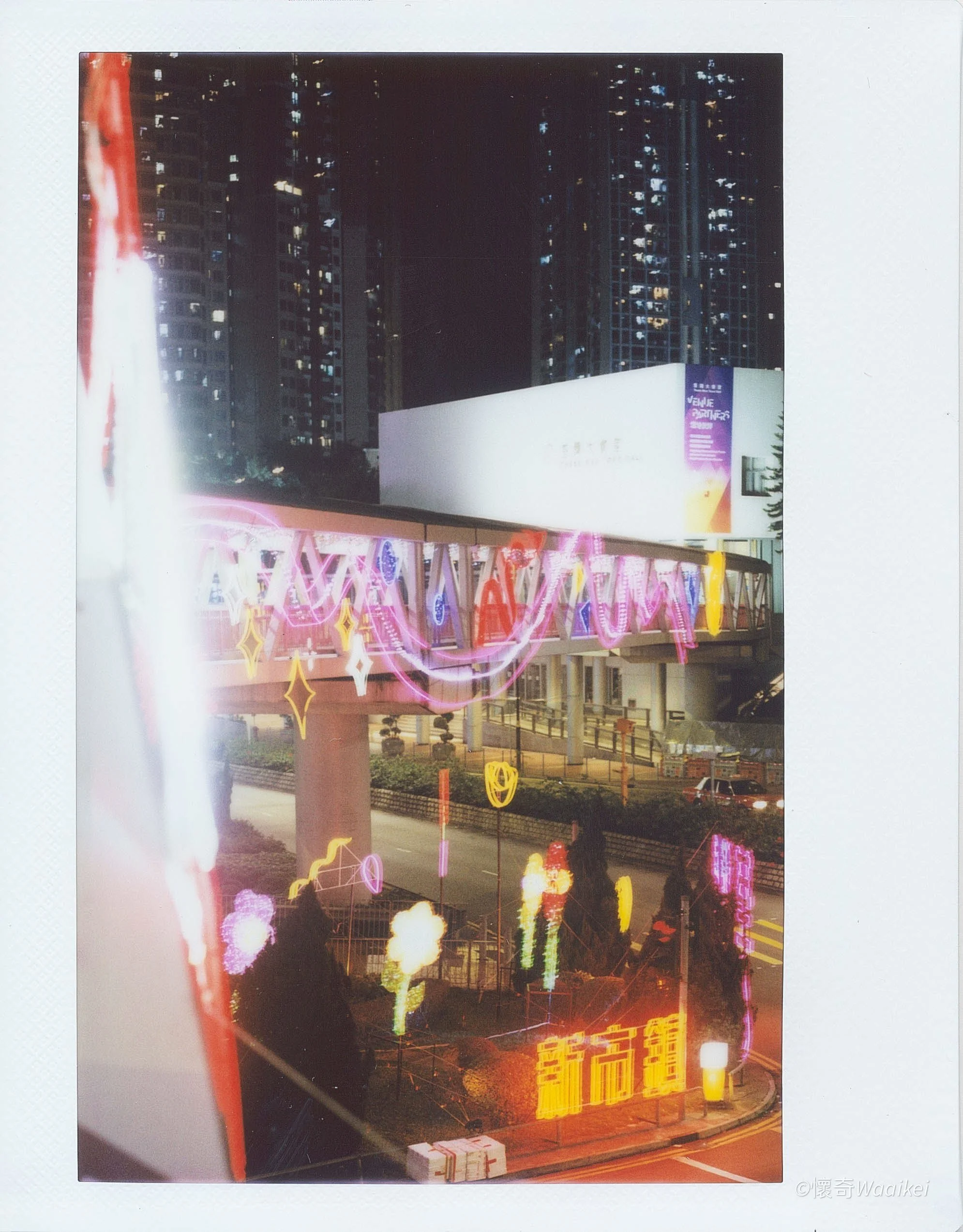 Nighttime cityscape with illuminated buildings, neon signs, and streetlights.