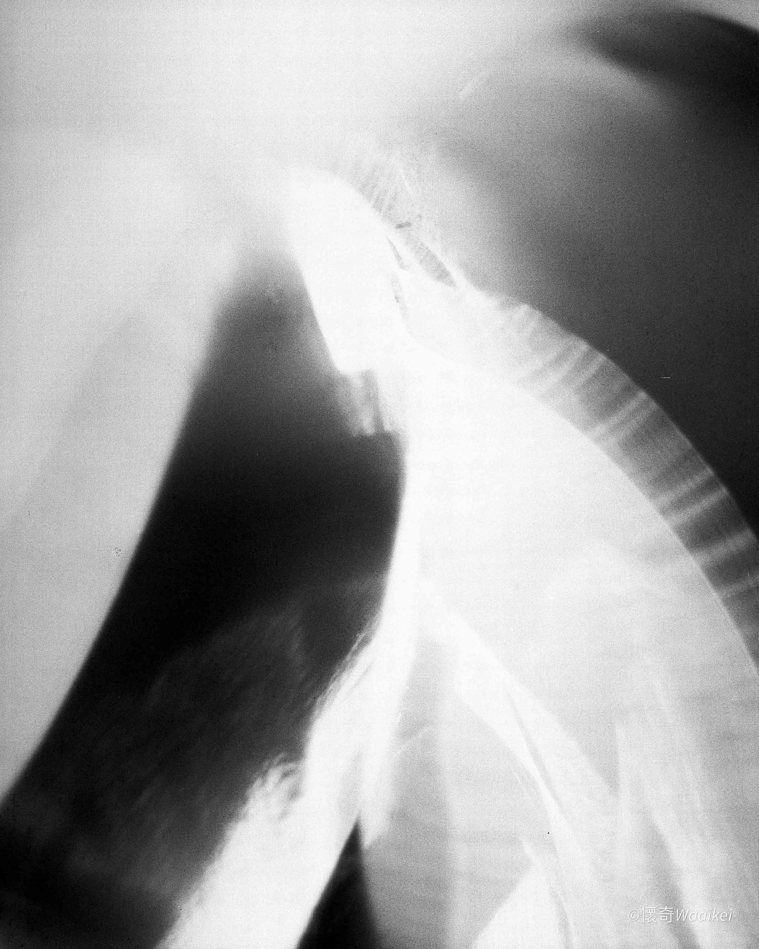 Close-up black and white photo of a person's foot with a shadow, taken from a low angle on the floor.