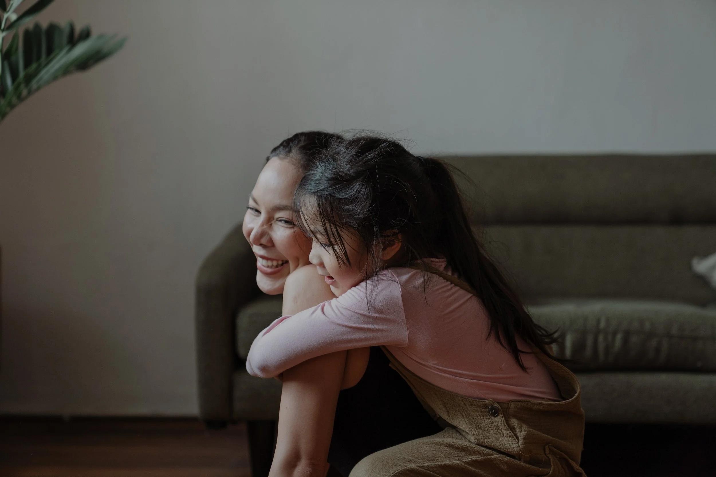 Smiling parent embracing a young child at home