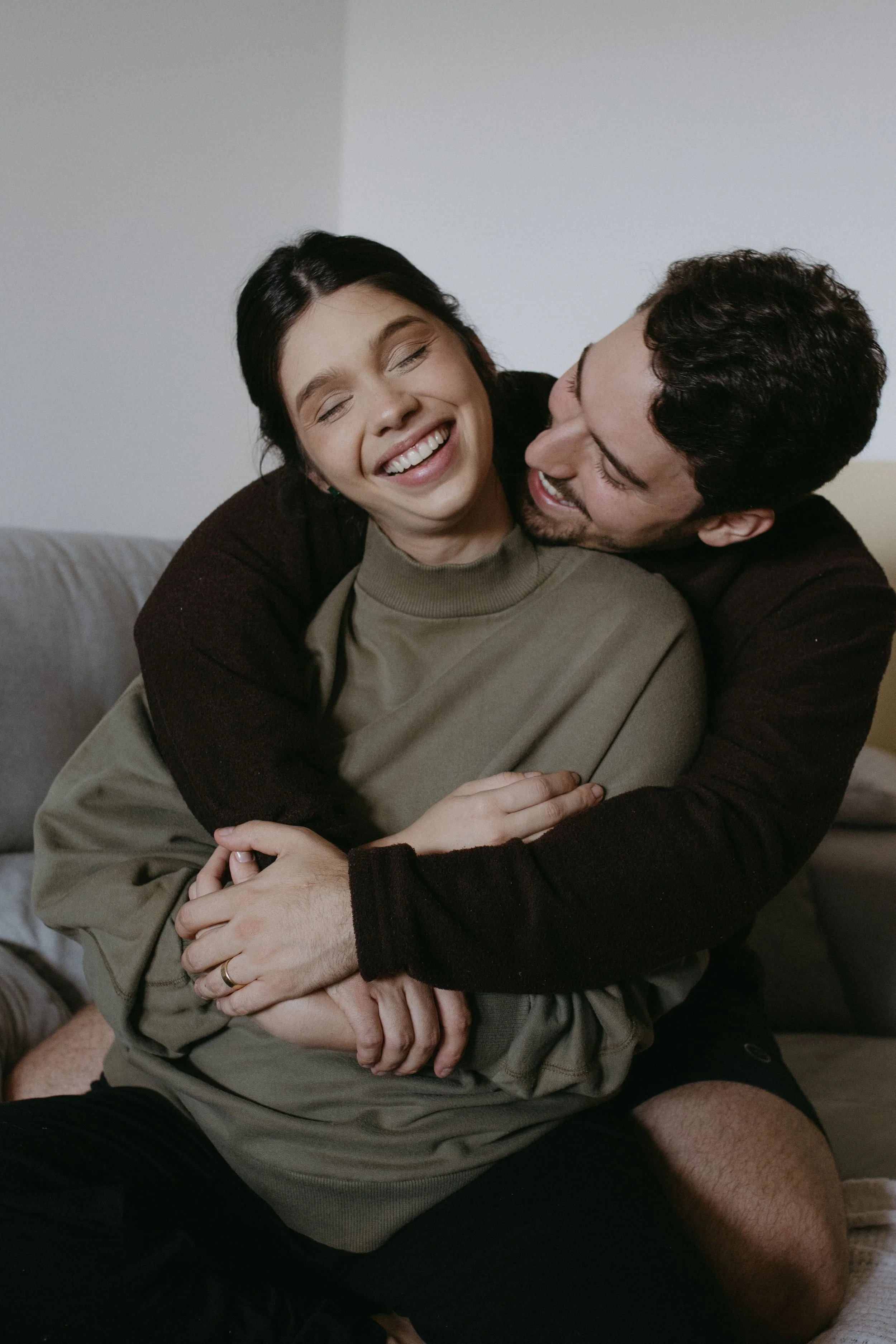 Couple laughing and embracing while seated together