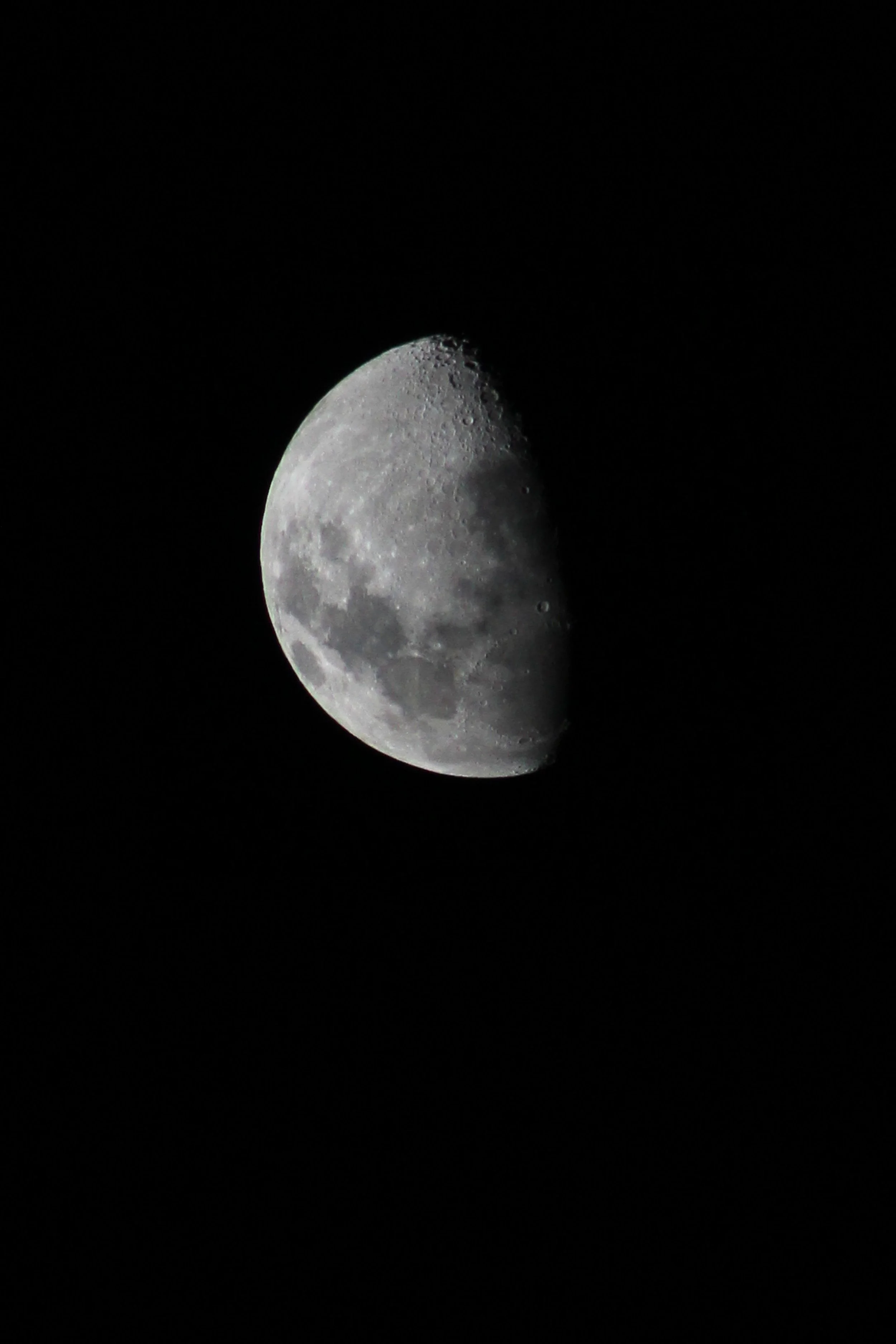 Close-up photograph of the moon showing its craters and surface details in a clear night sky.