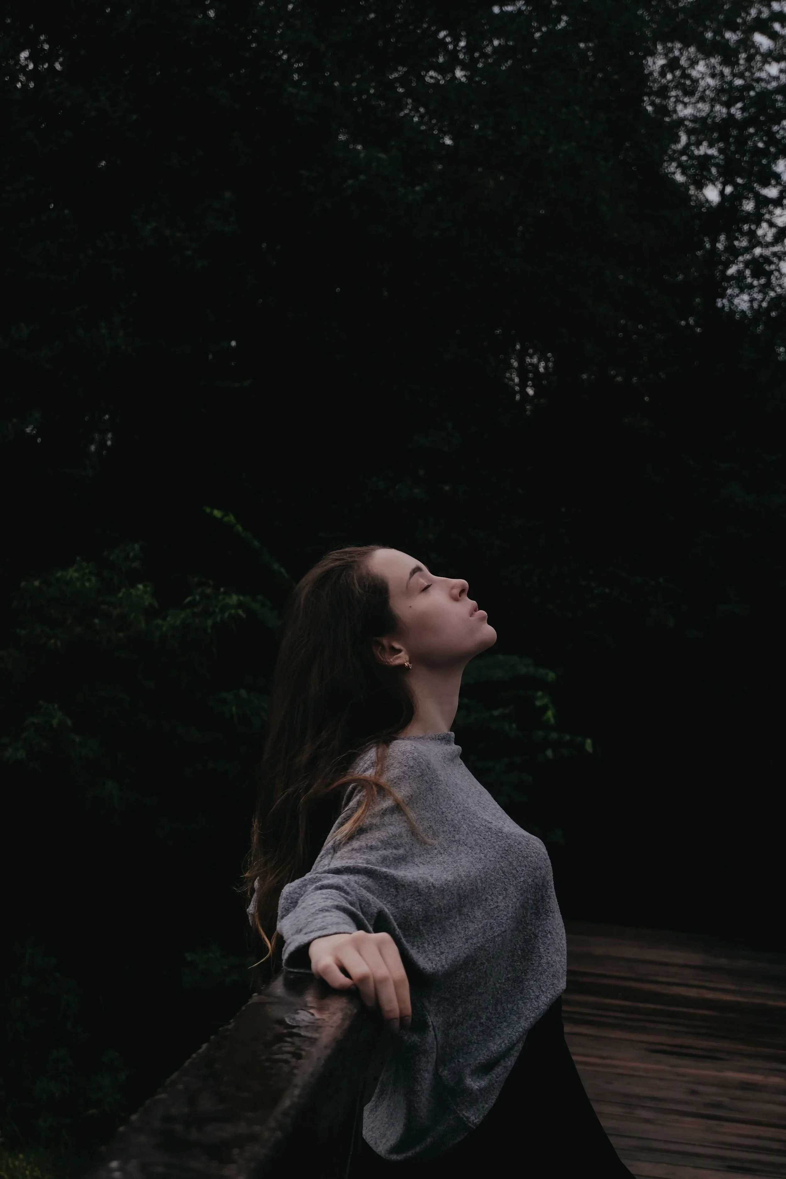 Woman taking a calming breath outdoors among trees