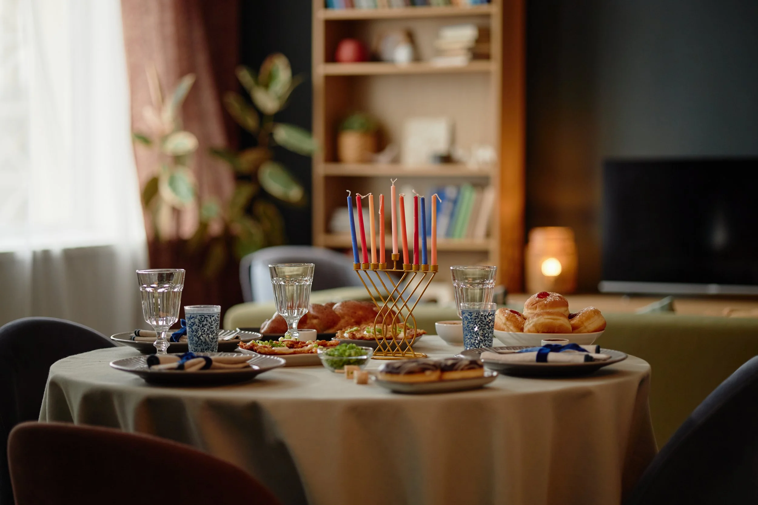 hanukkah-celebration-with-food-and-lit-menorah-2026-01-09-12-09-20-utc.jpg