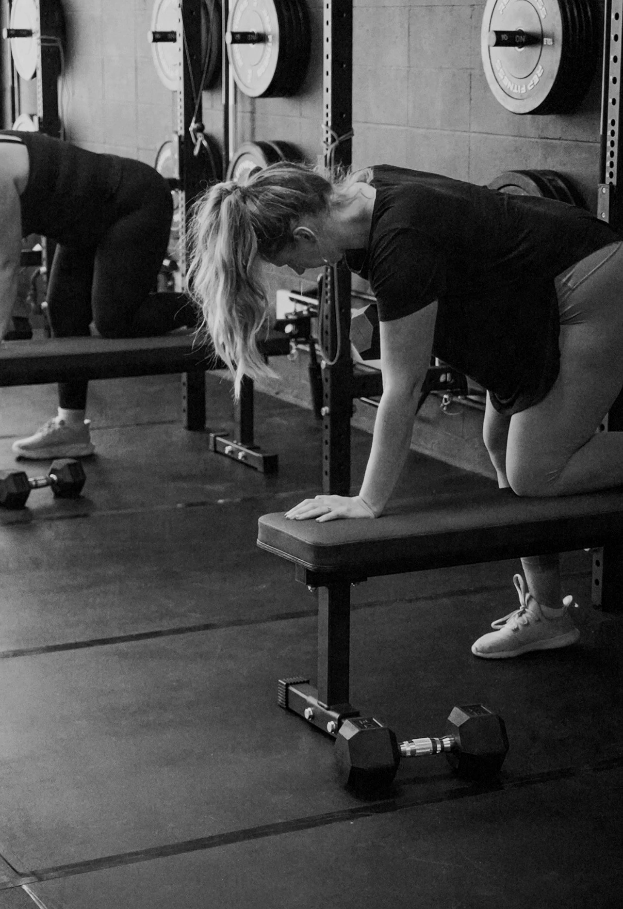 Woman preforming dumbell rows on a bench