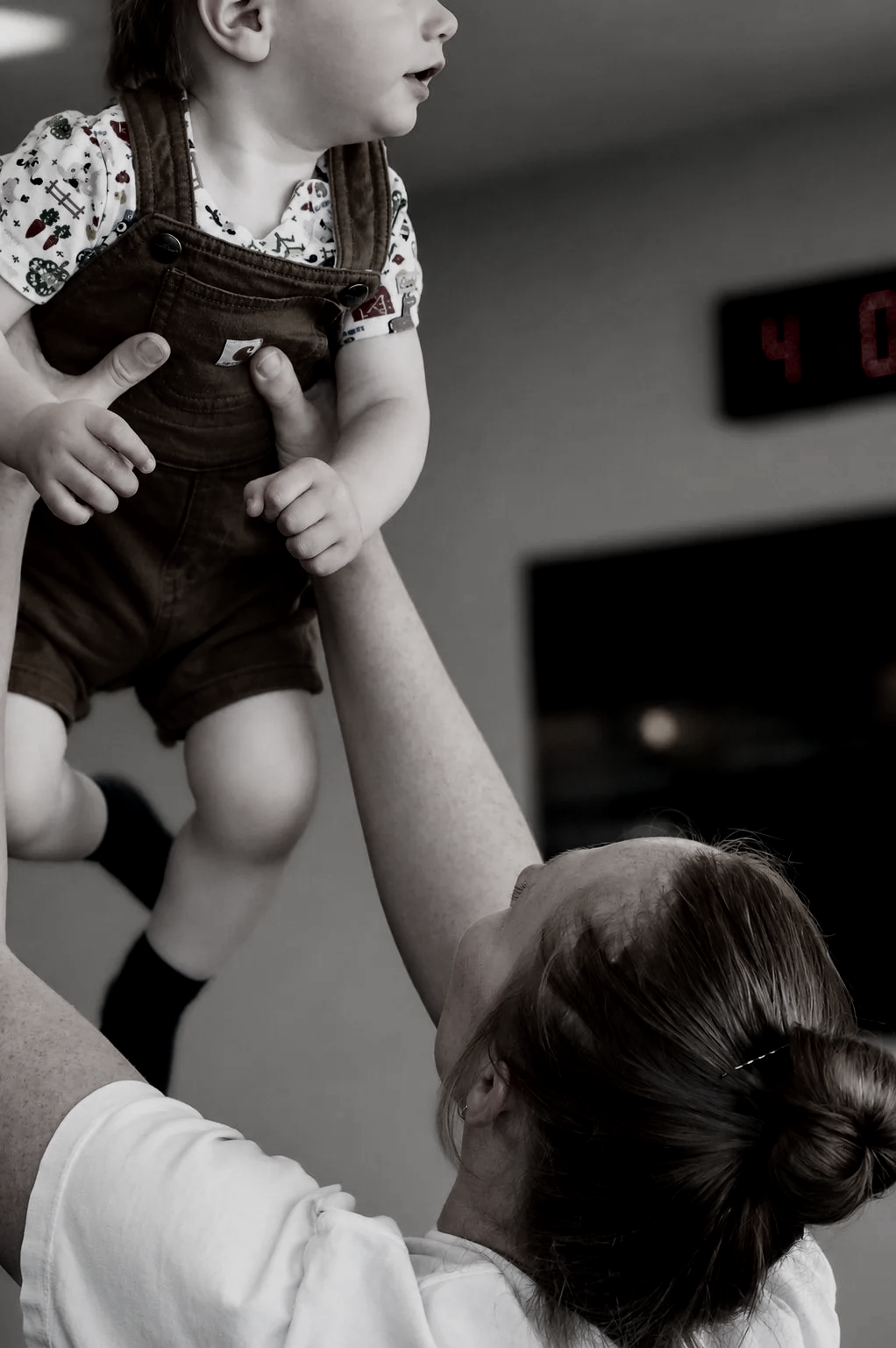 Woman holding up small child in womans only gym strength and grace collective in forest grove oregon