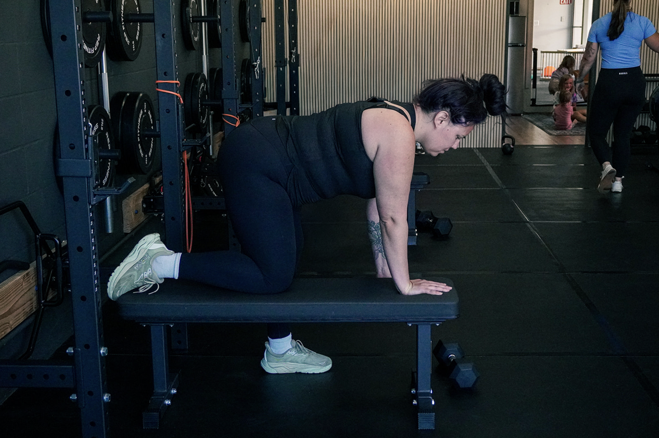 woman on gym bench lifting dumbell
